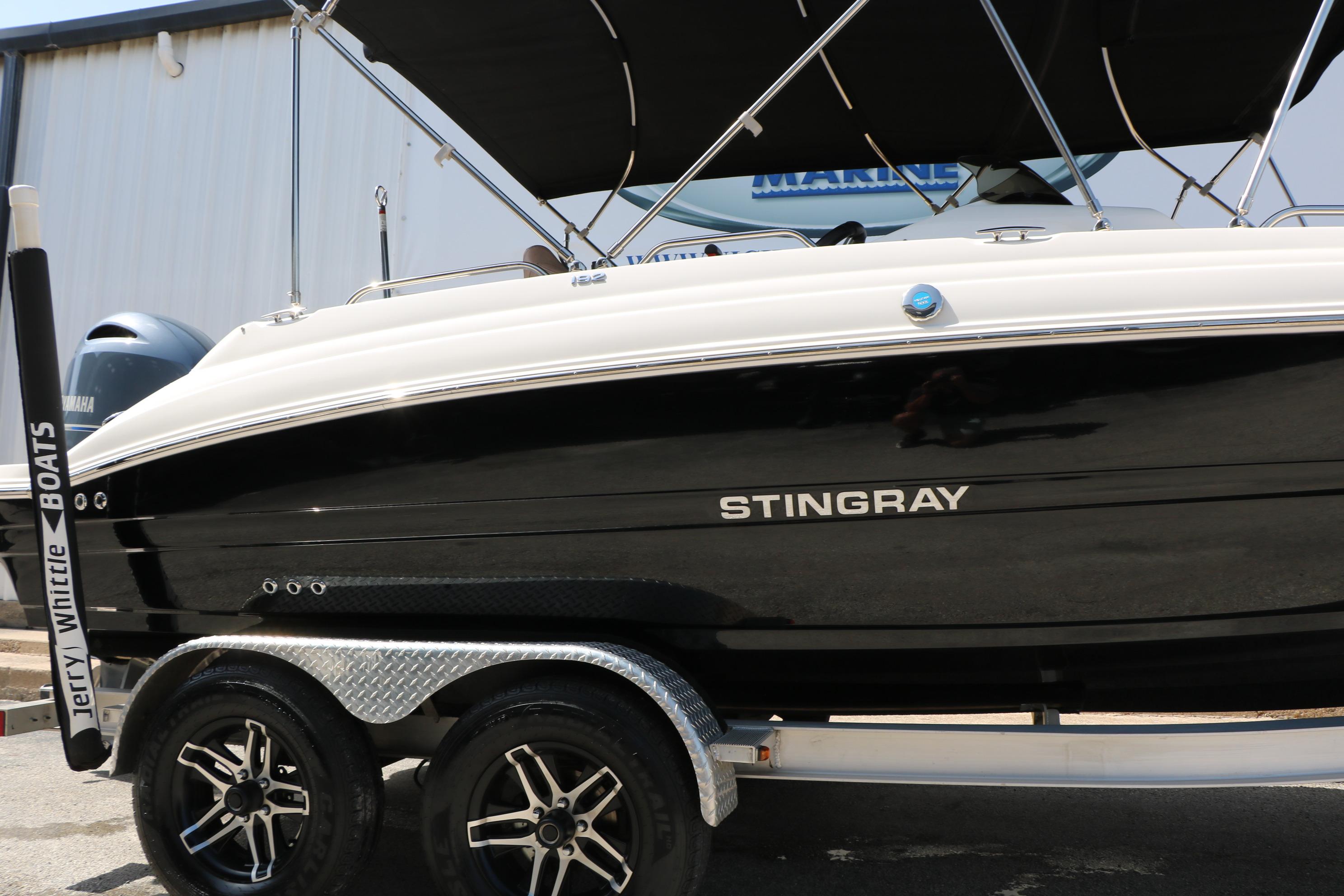 2022 Stingray 192 SC boat on trailer, black and white design, parked outdoors.
