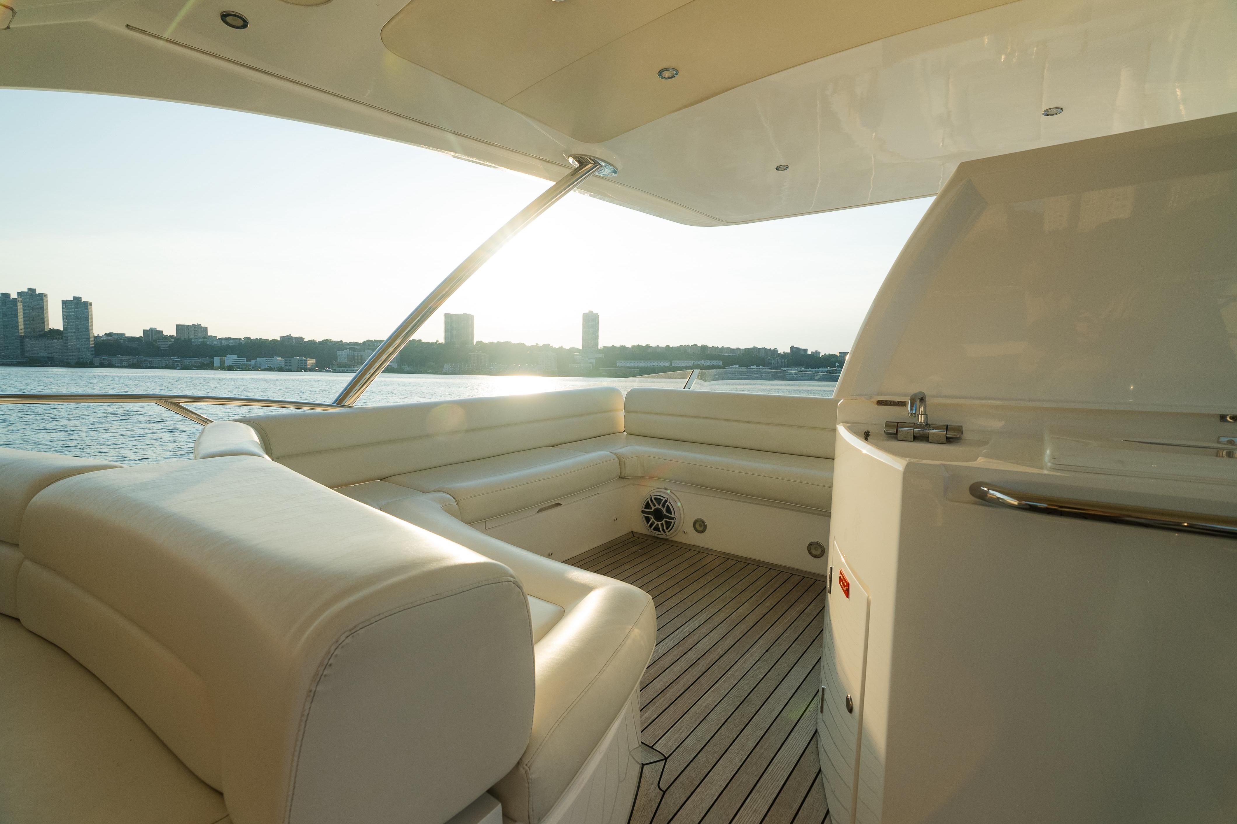 Luxurious 2016 Sunseeker Manhattan 65 yacht interior with waterfront view at sunset.