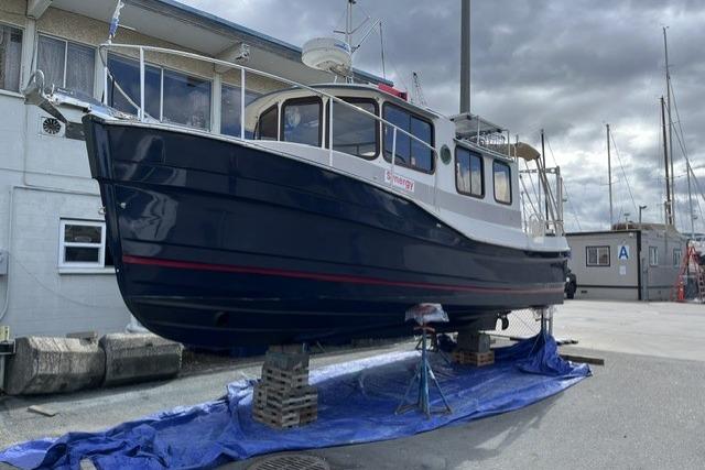 2008 Ranger 25 on dry dock, blue hull, marina background.