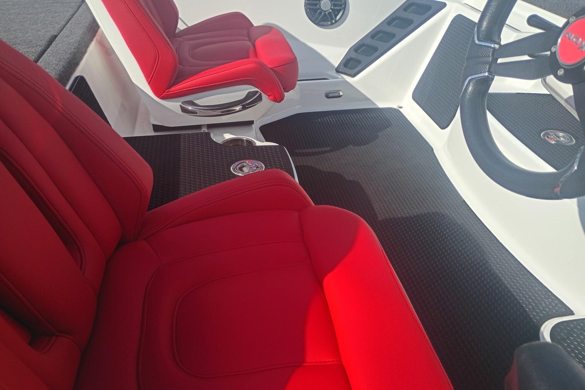 Red and black interior of 2024 iKon LX21 boat, featuring sleek seats and modern design.