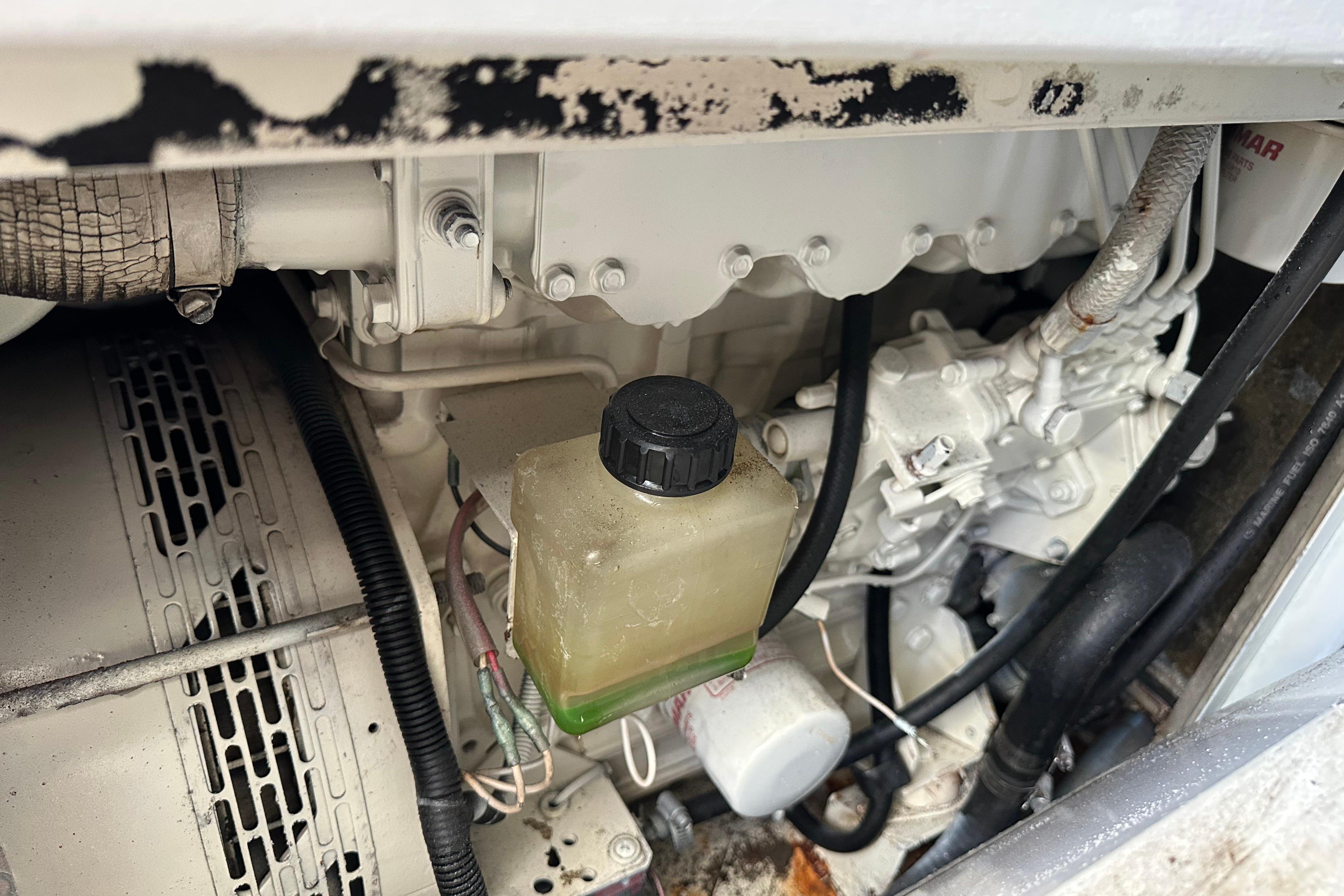 Engine compartment of a 2004 Azimut 55E yacht, showing mechanical components and fluid reservoir.