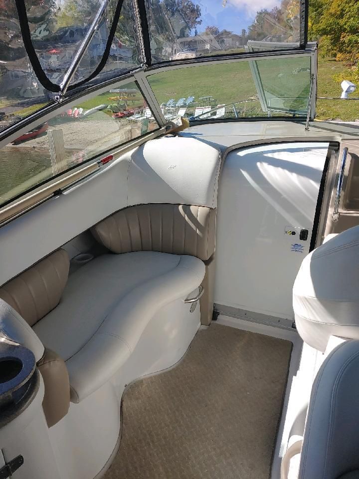 Interior of a boat with beige seating and large windows.