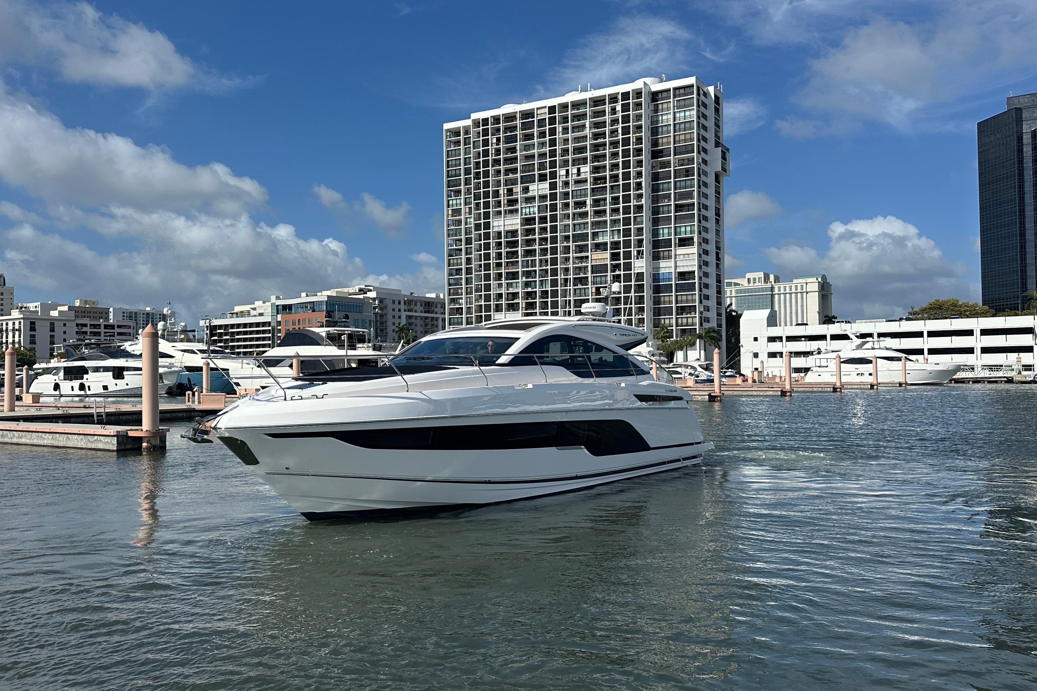 2026 Fairline Targa 47 GT yacht docked in a marina with cityscape background.