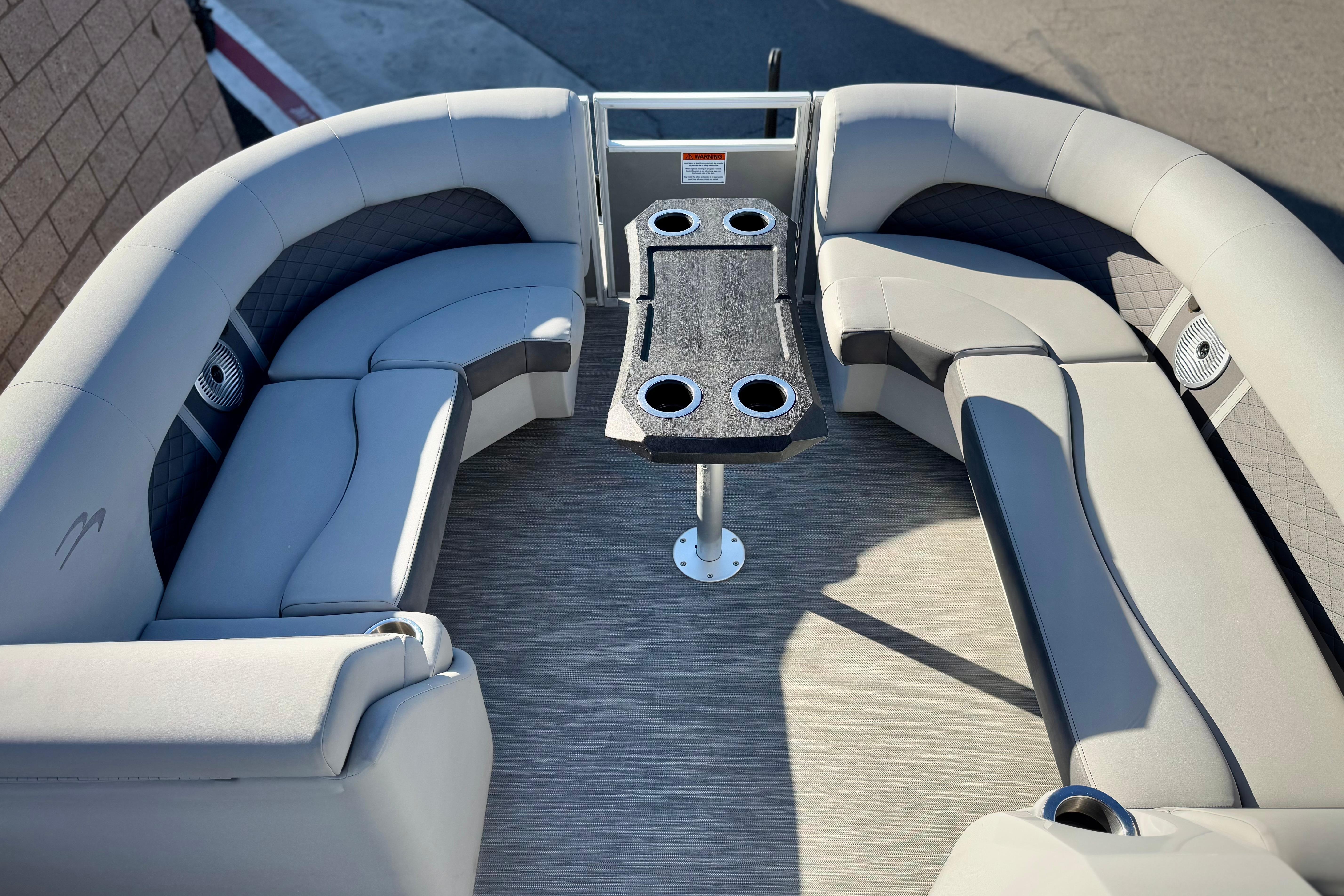 2021 Bennington 23LSR pontoon boat interior with plush seating and a central table.
