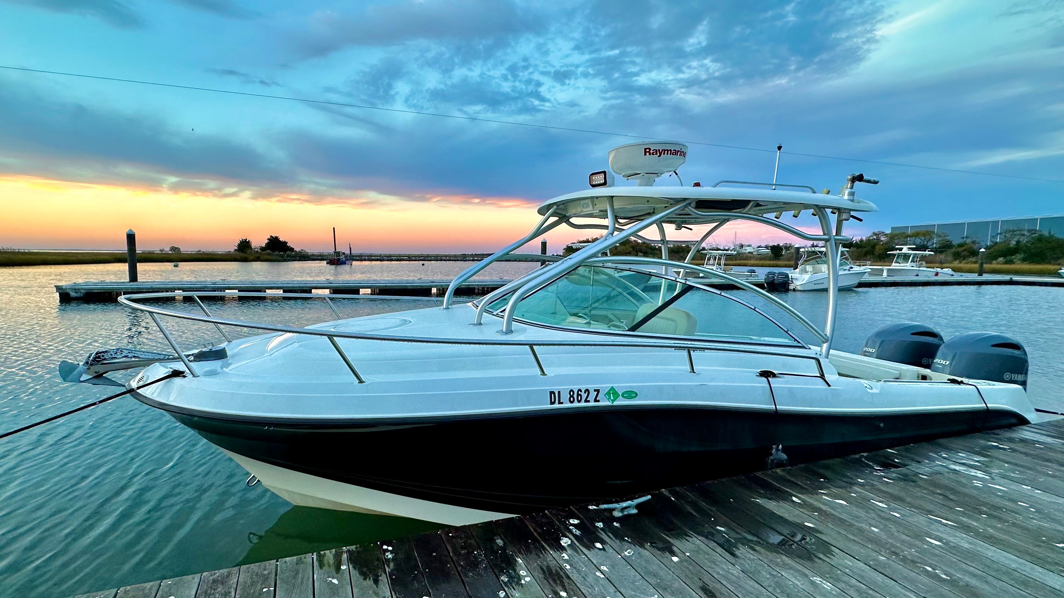 2023 Hydra-Sports Vector-VX docked at sunset, featuring dual outboard engines.