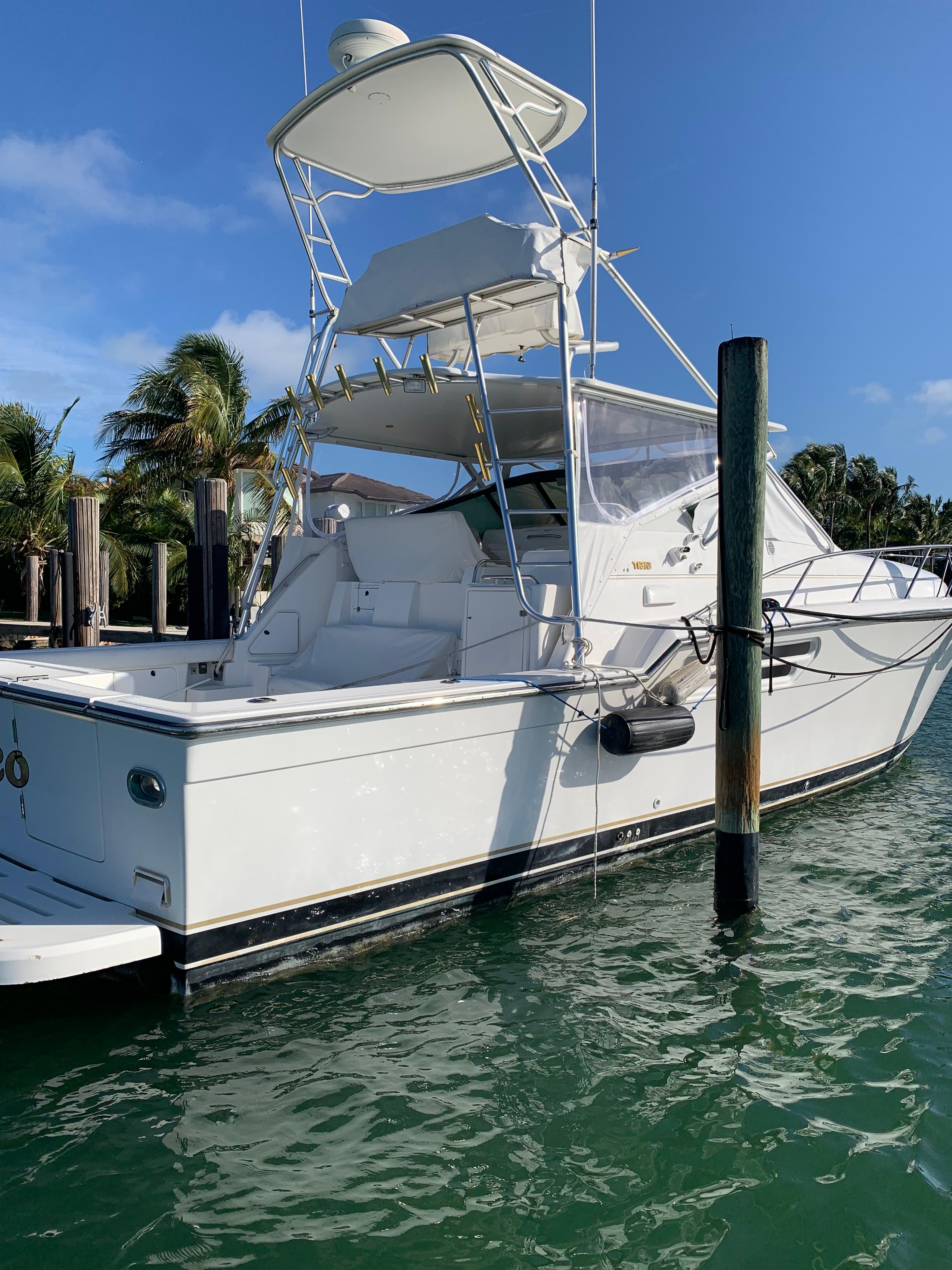 1999 Tiara Yachts 43 Open docked in sunny marina.