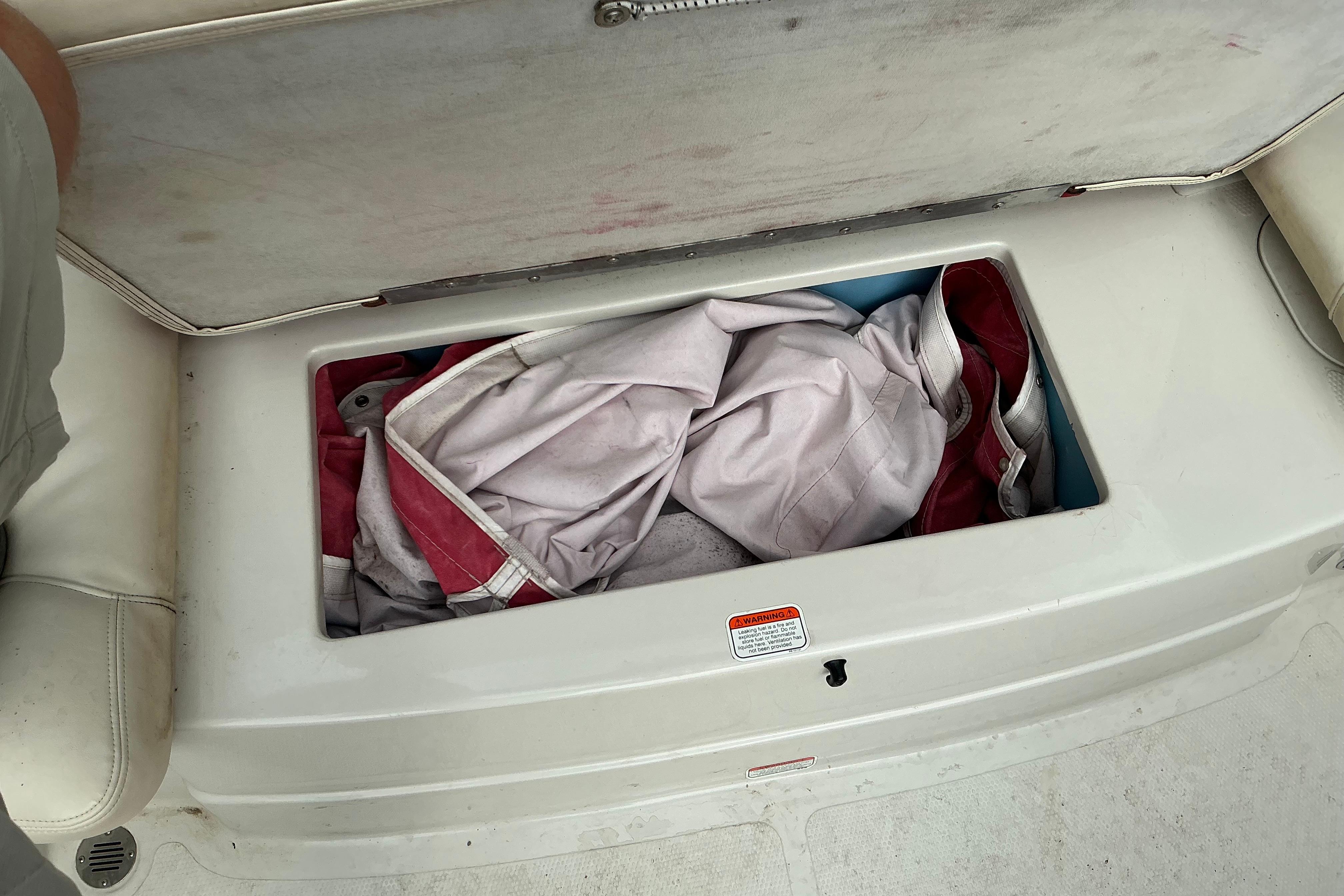 Storage compartment on a 2014 Tahoe Q7i boat with life jackets inside.