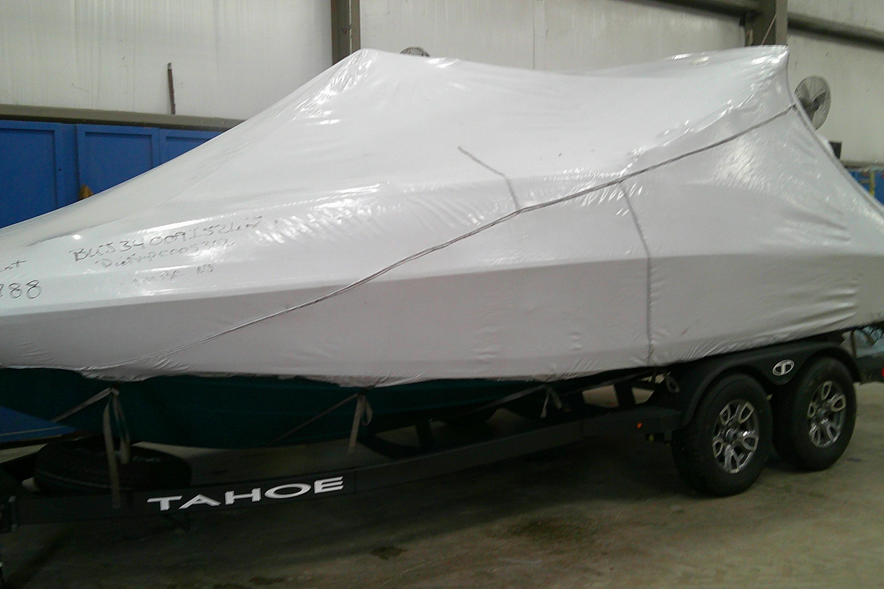 Covered 2026 Tahoe 2150 CC boat on trailer in storage facility.