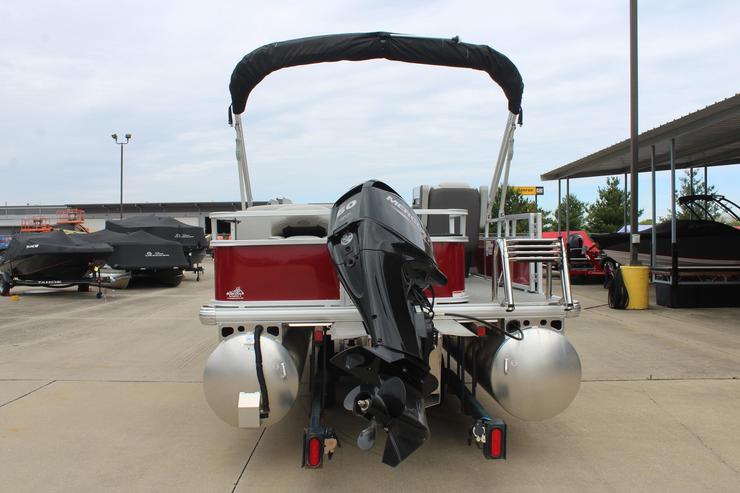 2026 Sun Tracker Bass Buggy 18 DLX pontoon boat with outboard motor, parked outdoors.