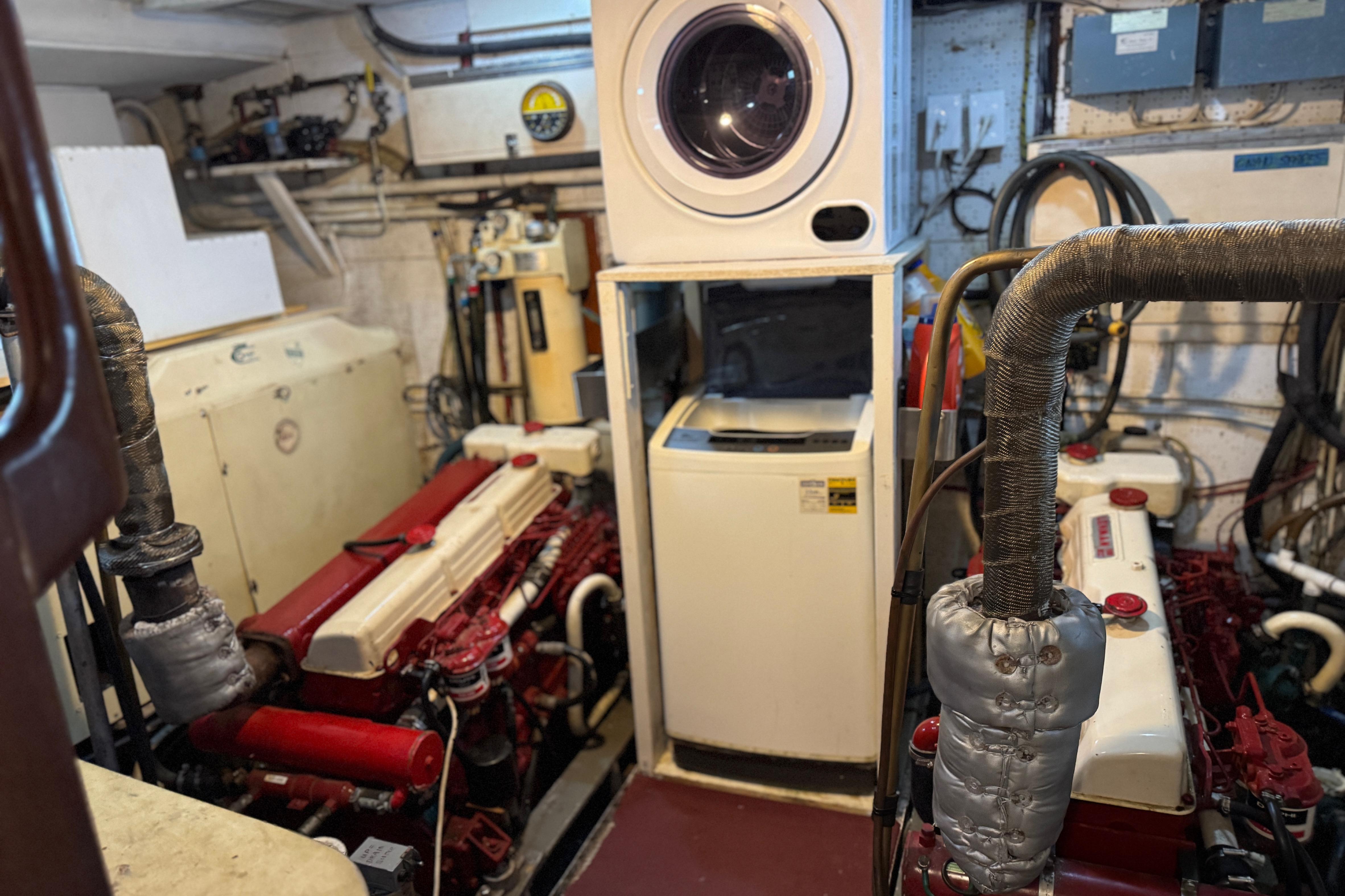 Engine room of a 1979 Cheoy Lee 46 LRC yacht with washer and dryer.