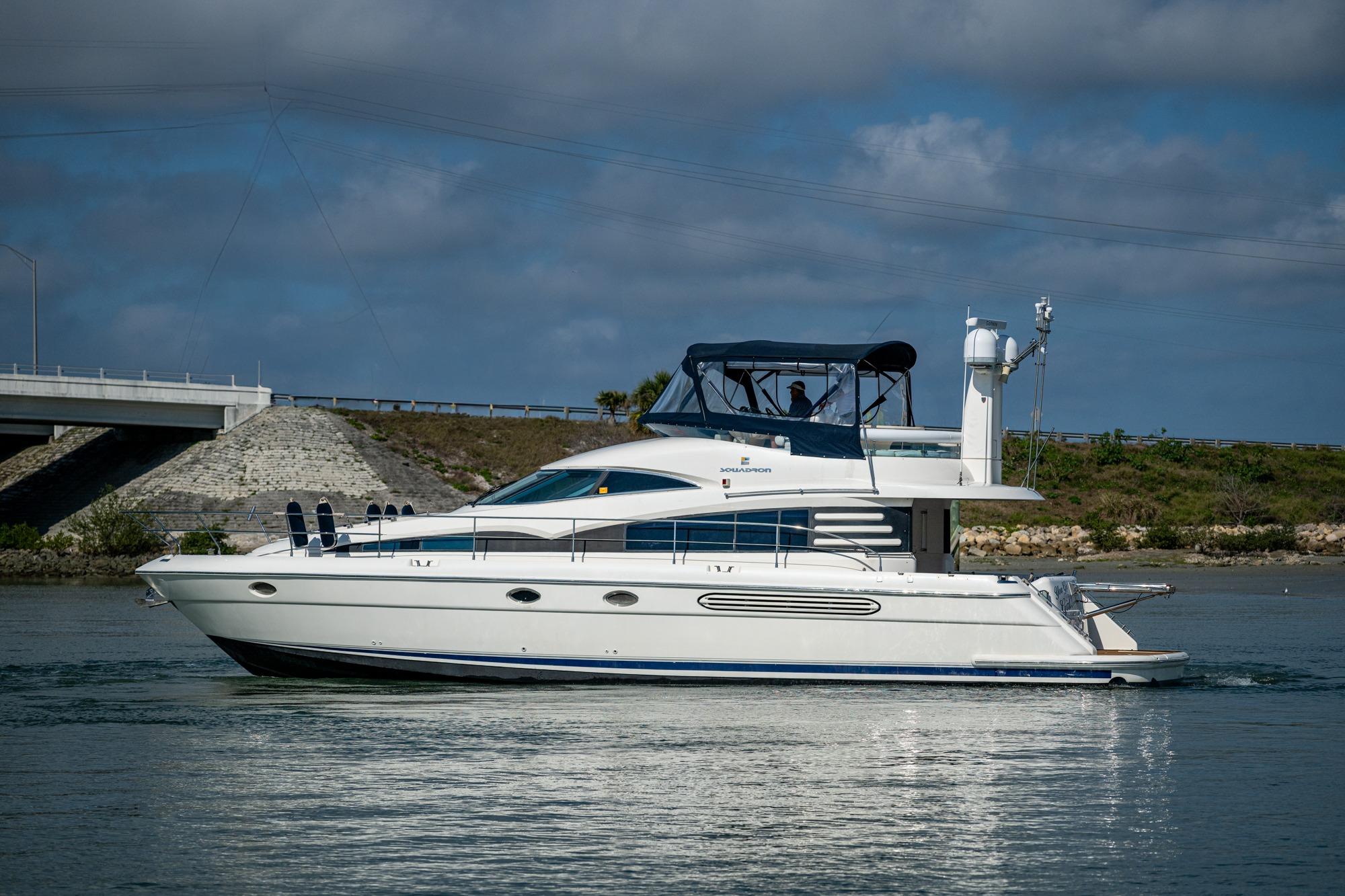 Luxury Fairline Squadron 52 yacht from 2000 cruising on a calm waterway.