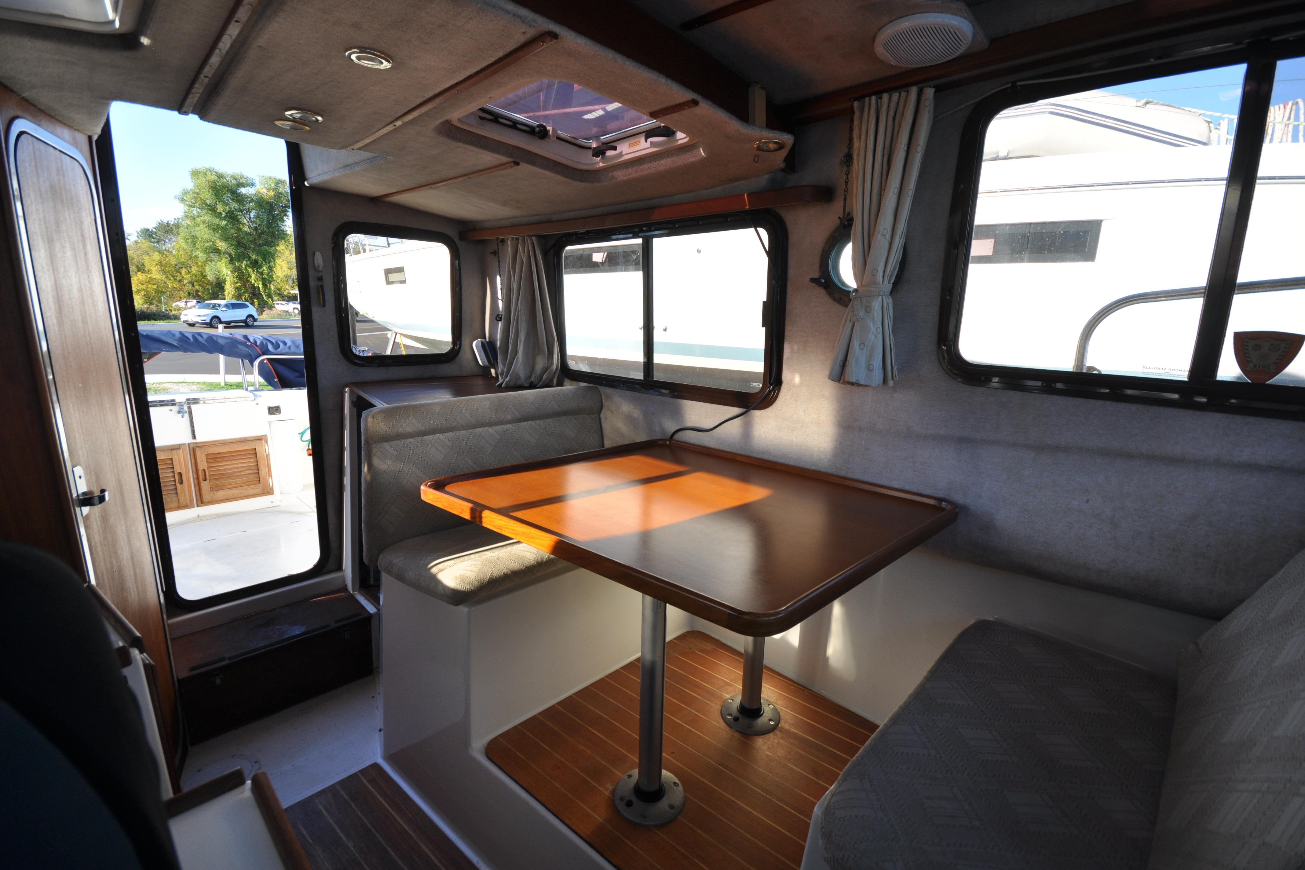 Cozy interior of 2007 Ranger Tug R-25 with dining area and windows.