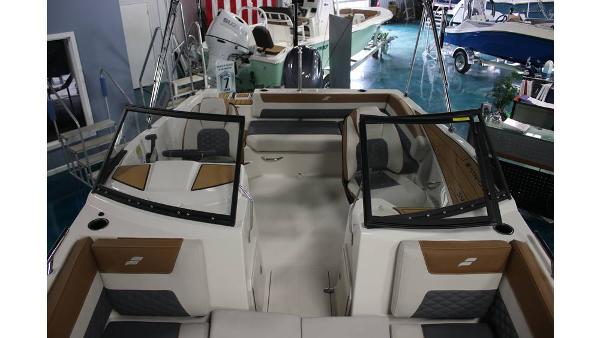2025 Starcraft SVX 190 OB DC boat interior with seating and windshield, displayed in showroom.