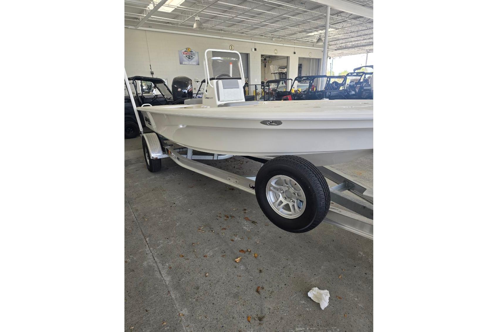 2026 Mako 18 Pro Skiff boat on trailer in showroom.