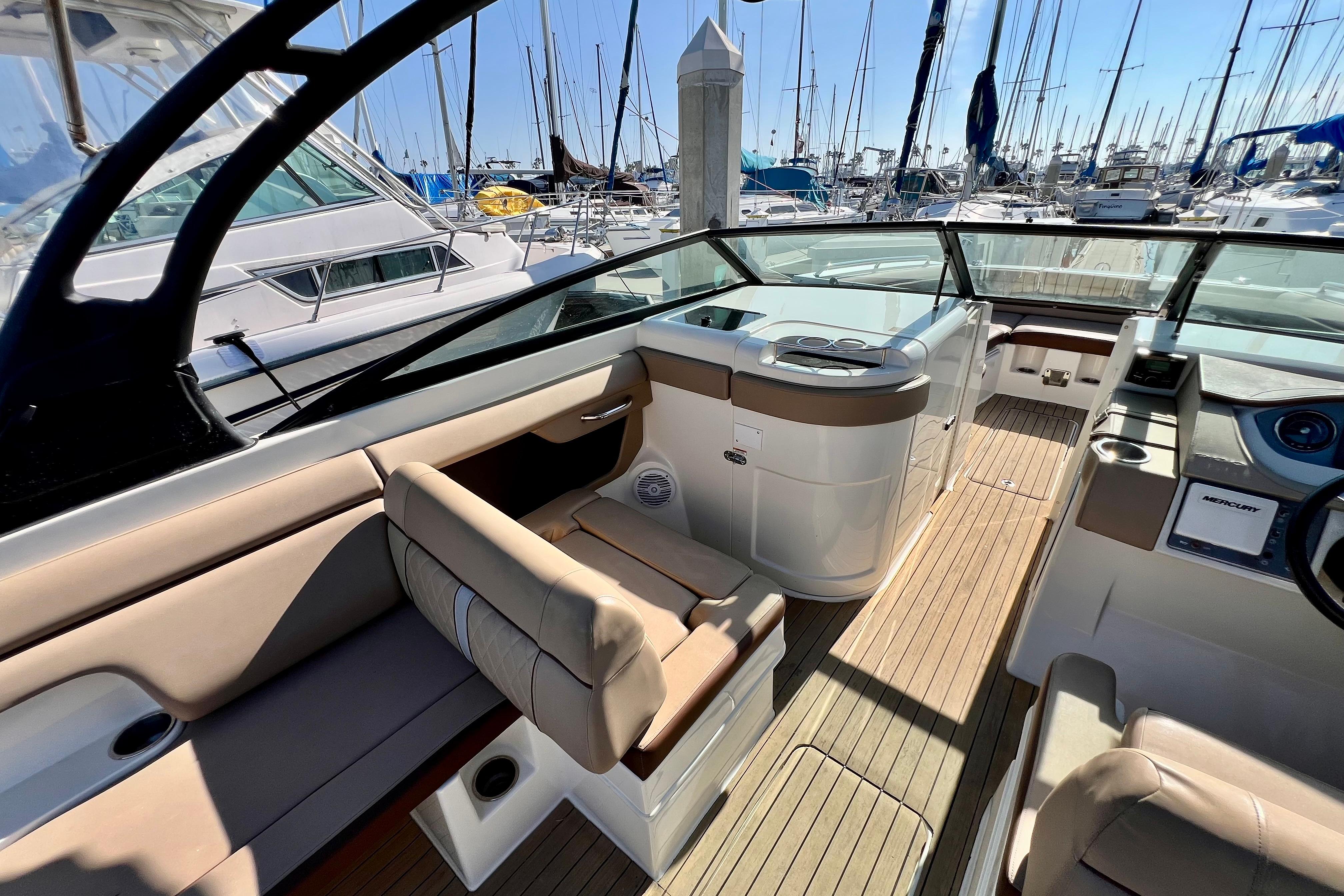 2016 Sea Ray 290 Sundeck Outboard interior with seating and helm, docked at marina.