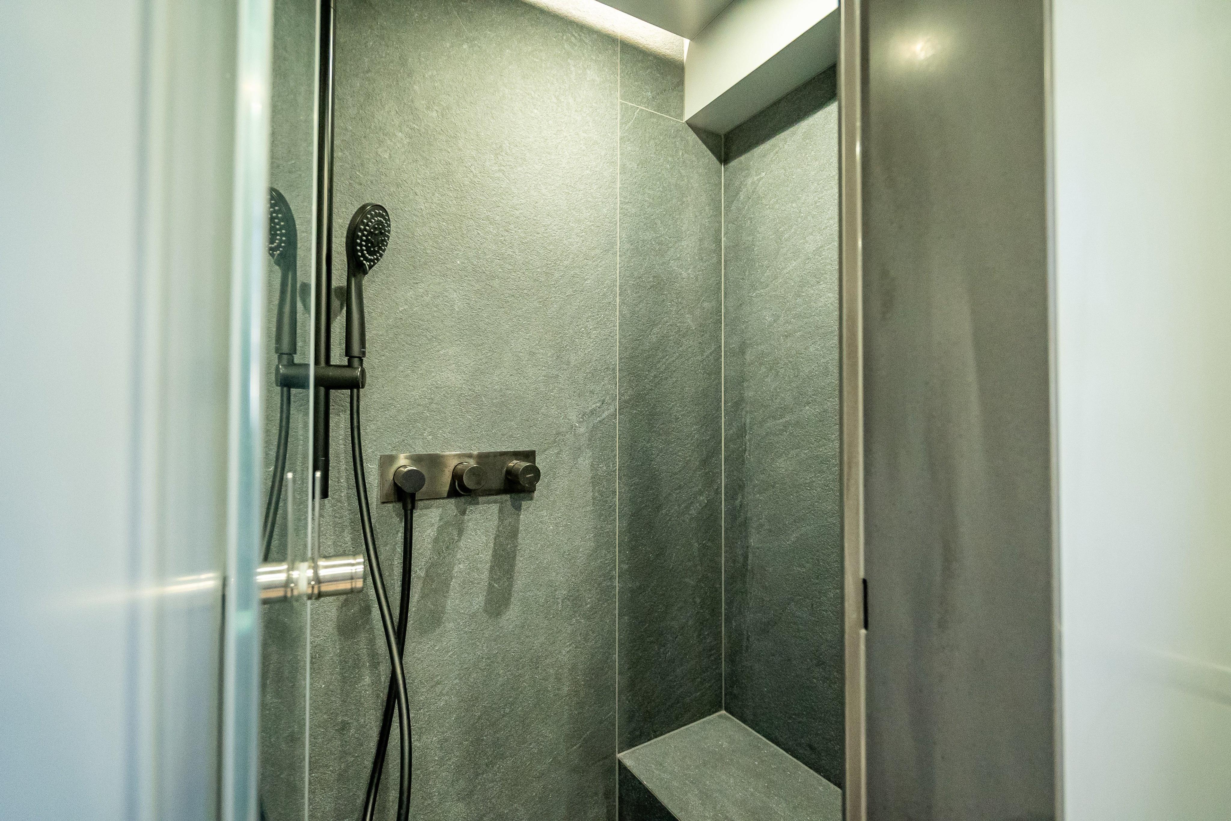 Modern shower in 2026 Sunreef 60 Power yacht, featuring sleek design and dark tiles.