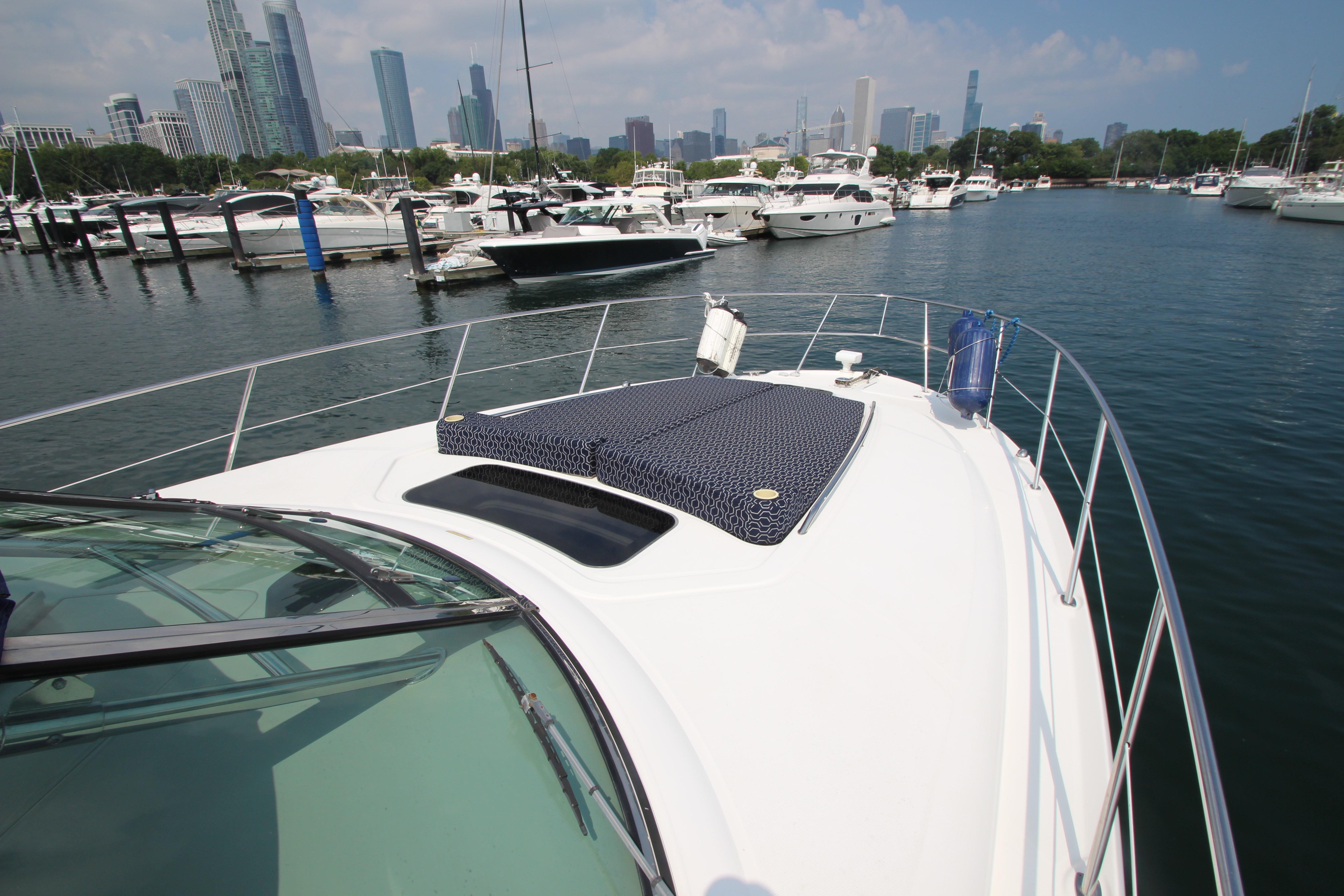 2004 Sea Ray 40 Sundancer yacht docked in a marina with city skyline.