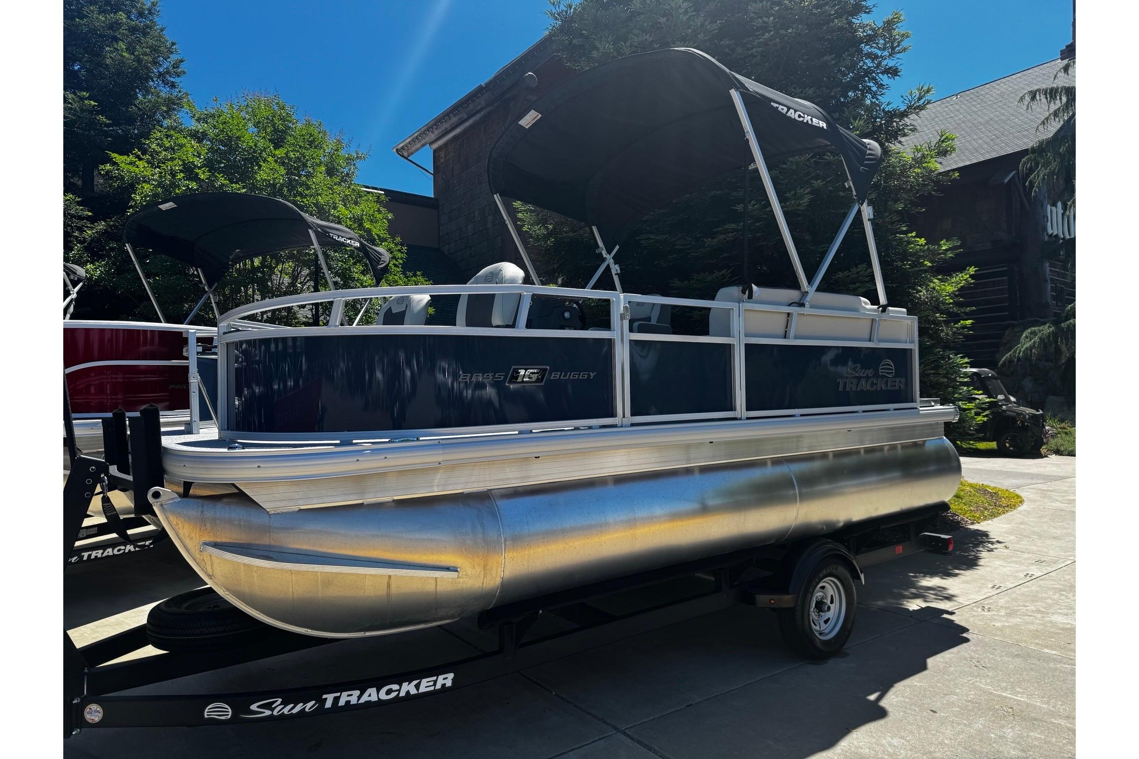 2026 Sun Tracker Bass Buggy 16 XL Select pontoon boat on trailer, outdoors.
