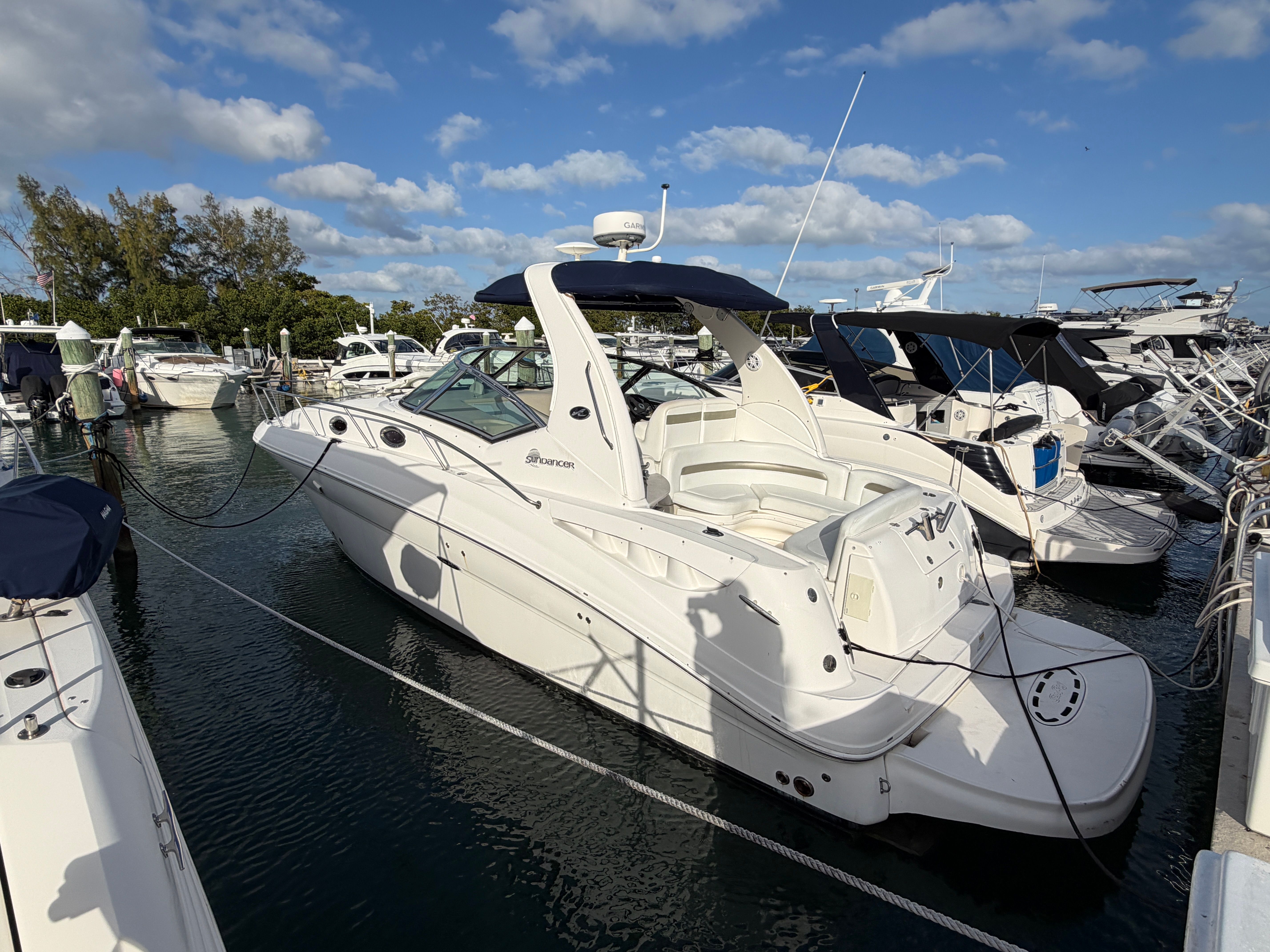 2006 Sea Ray Sundancer 320 docked, surrounded by other boats, under a blue sky.
