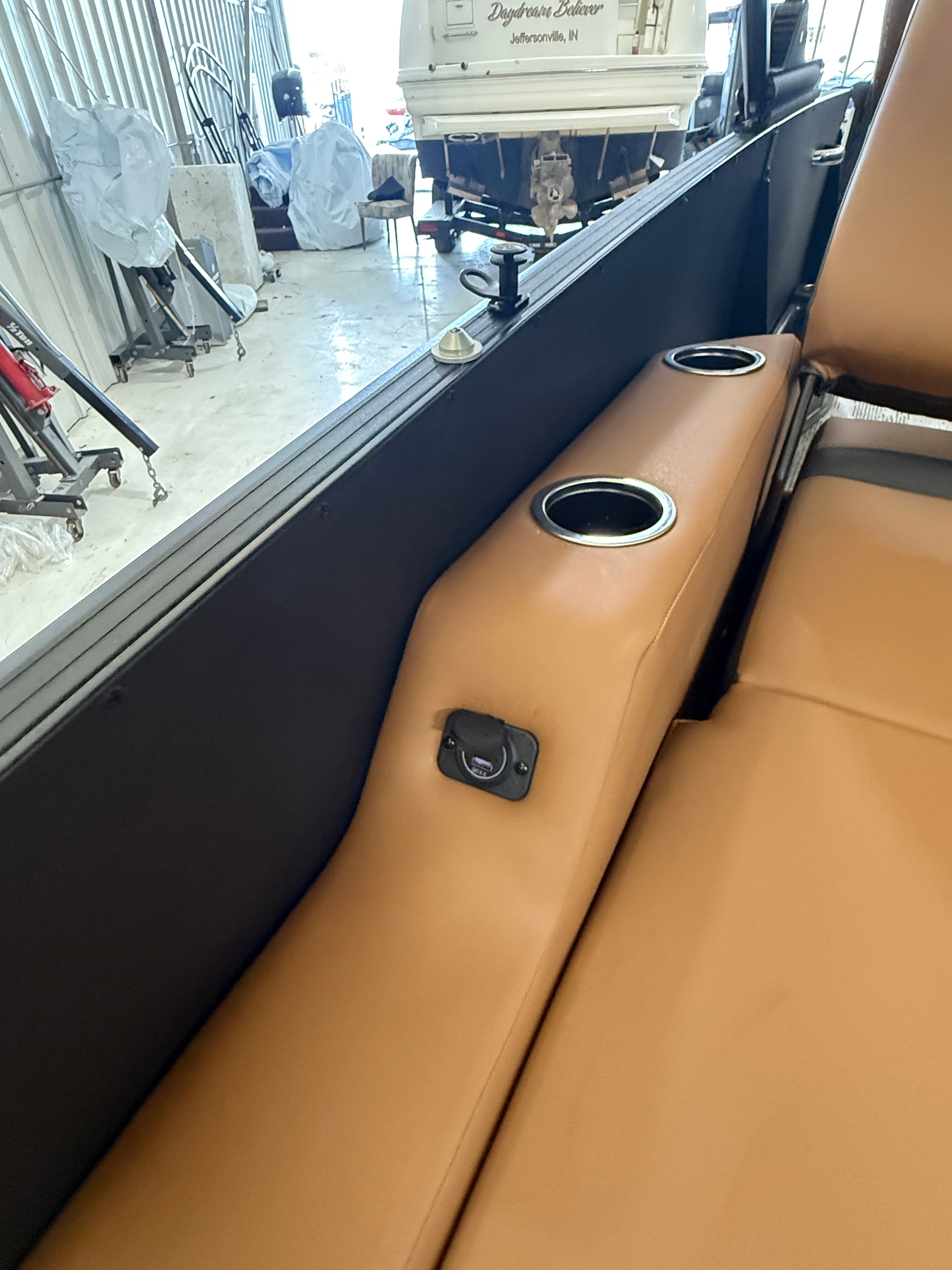 Close-up of a boat seat with brown upholstery and cup holders.