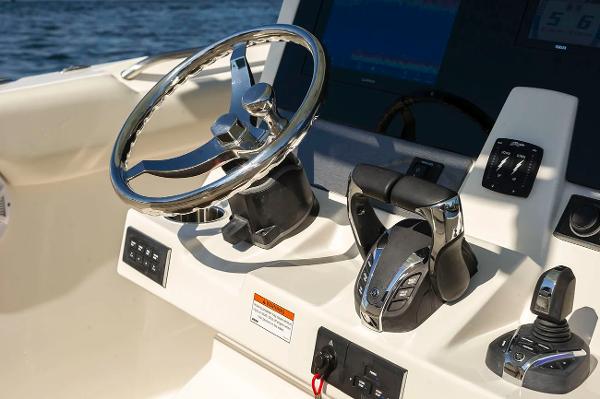 Manufacturer Provided Image: Steering console of 2026 Sailfish 312 CC boat with modern controls and chrome wheel.