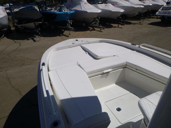 2024 Ranger 2360 Bay boat interior with white seating, parked among covered boats.