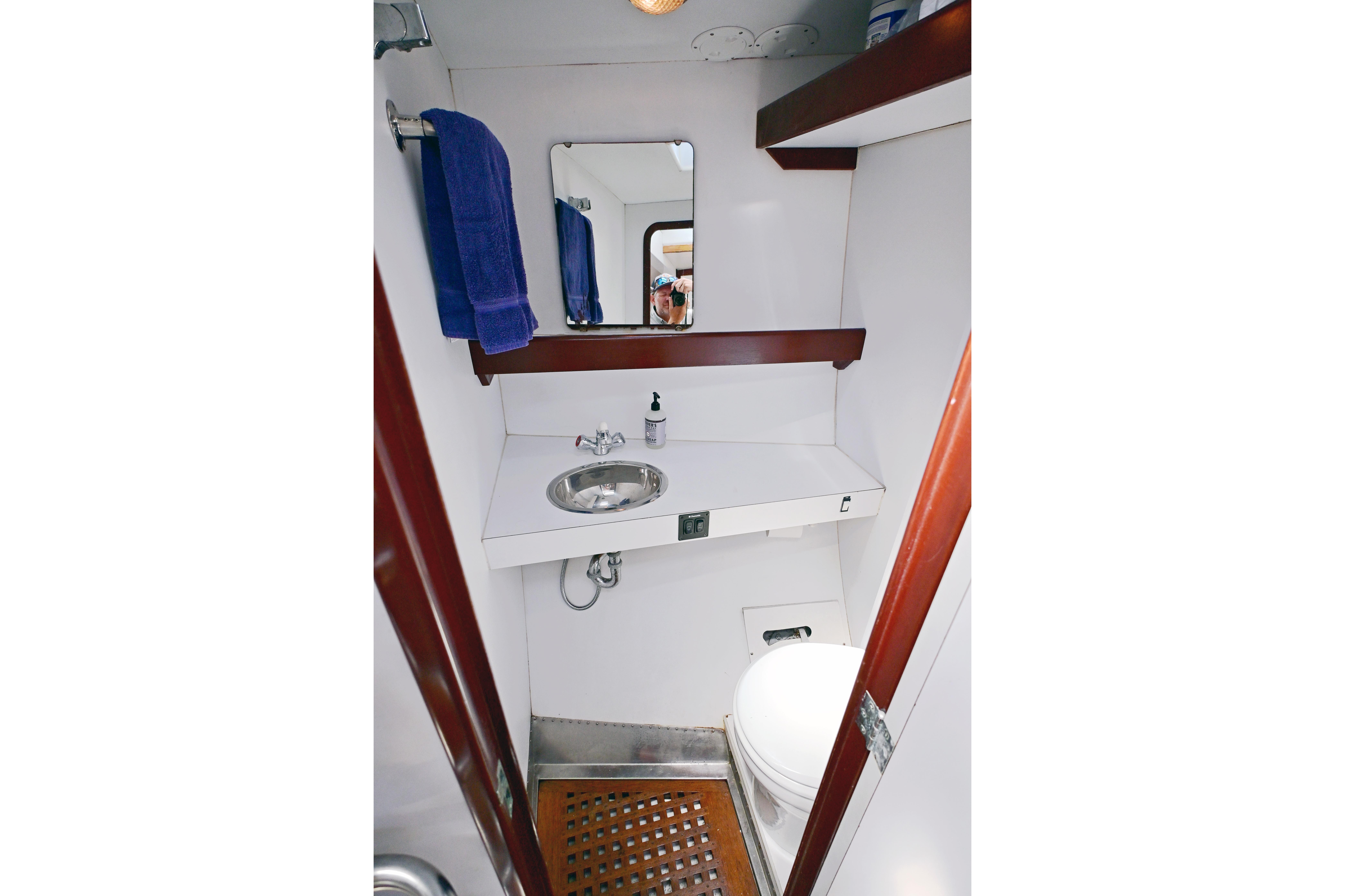 Bathroom interior of 1968 Abeking & Rasmussen Tripp 74 yacht, featuring sink, mirror, and toilet.