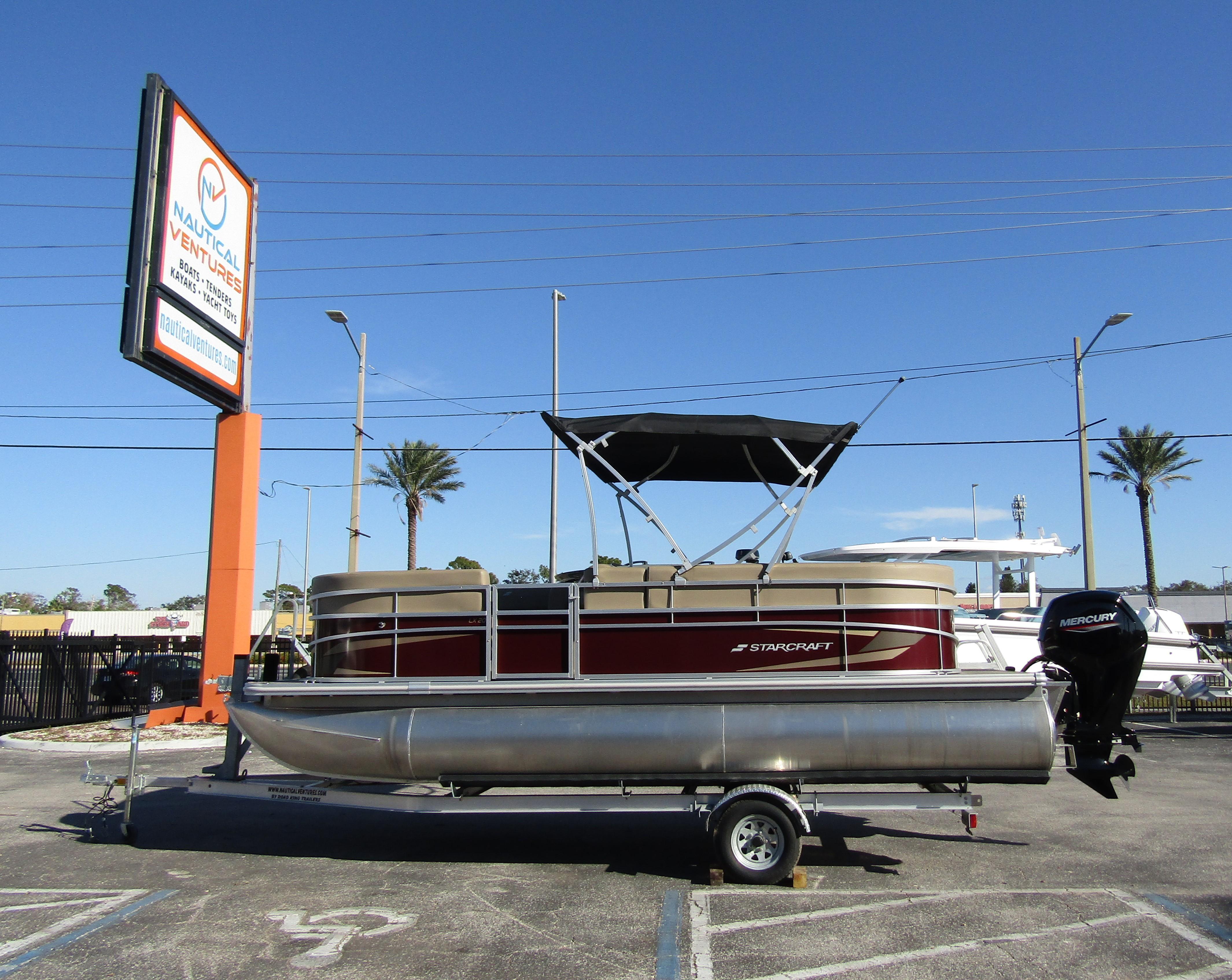 2024 Starcraft LX 20 R pontoon boat on trailer in sunny parking lot.