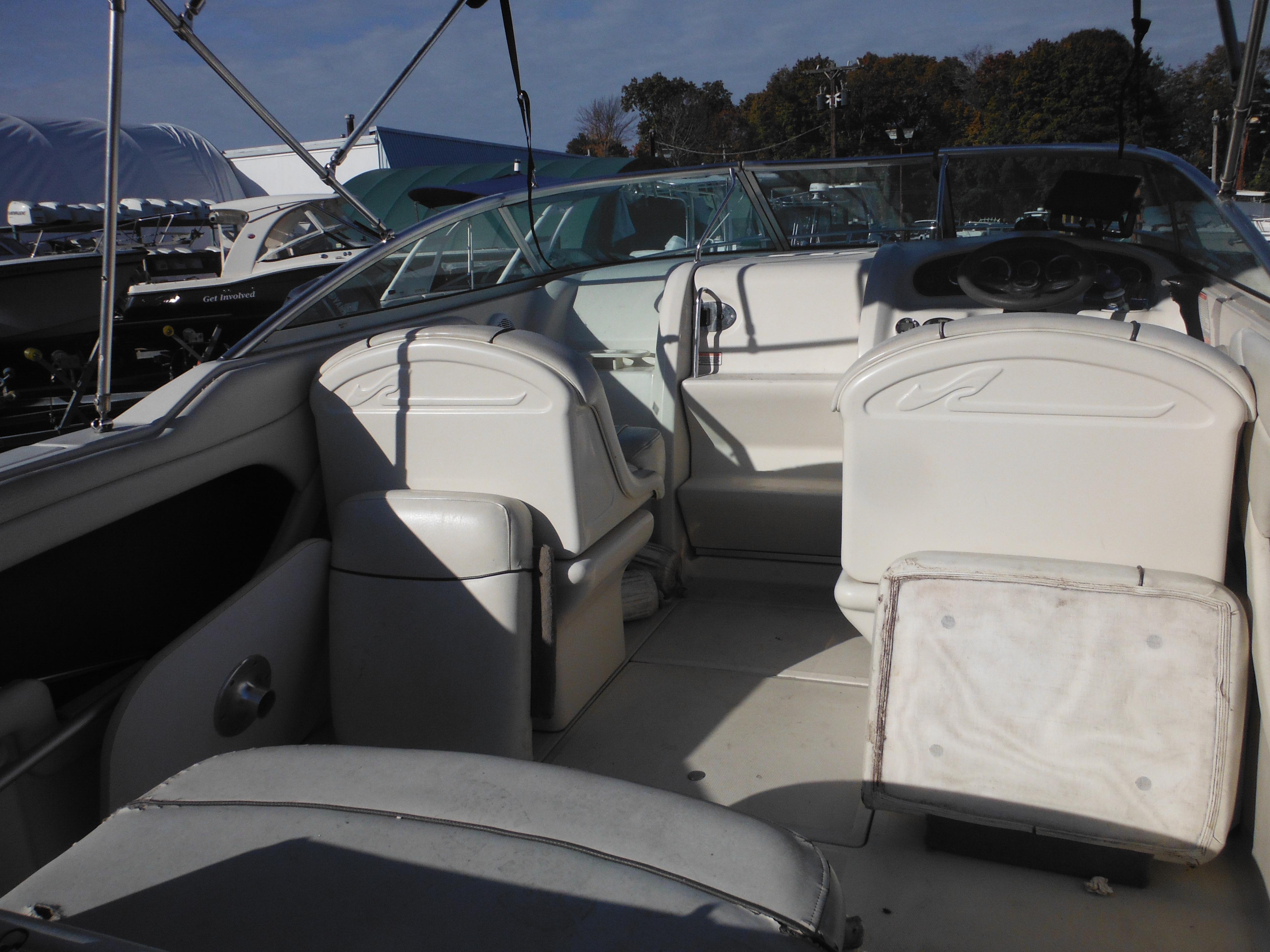 2004 Sea Ray 215 Weekender boat interior with white seating and steering wheel.