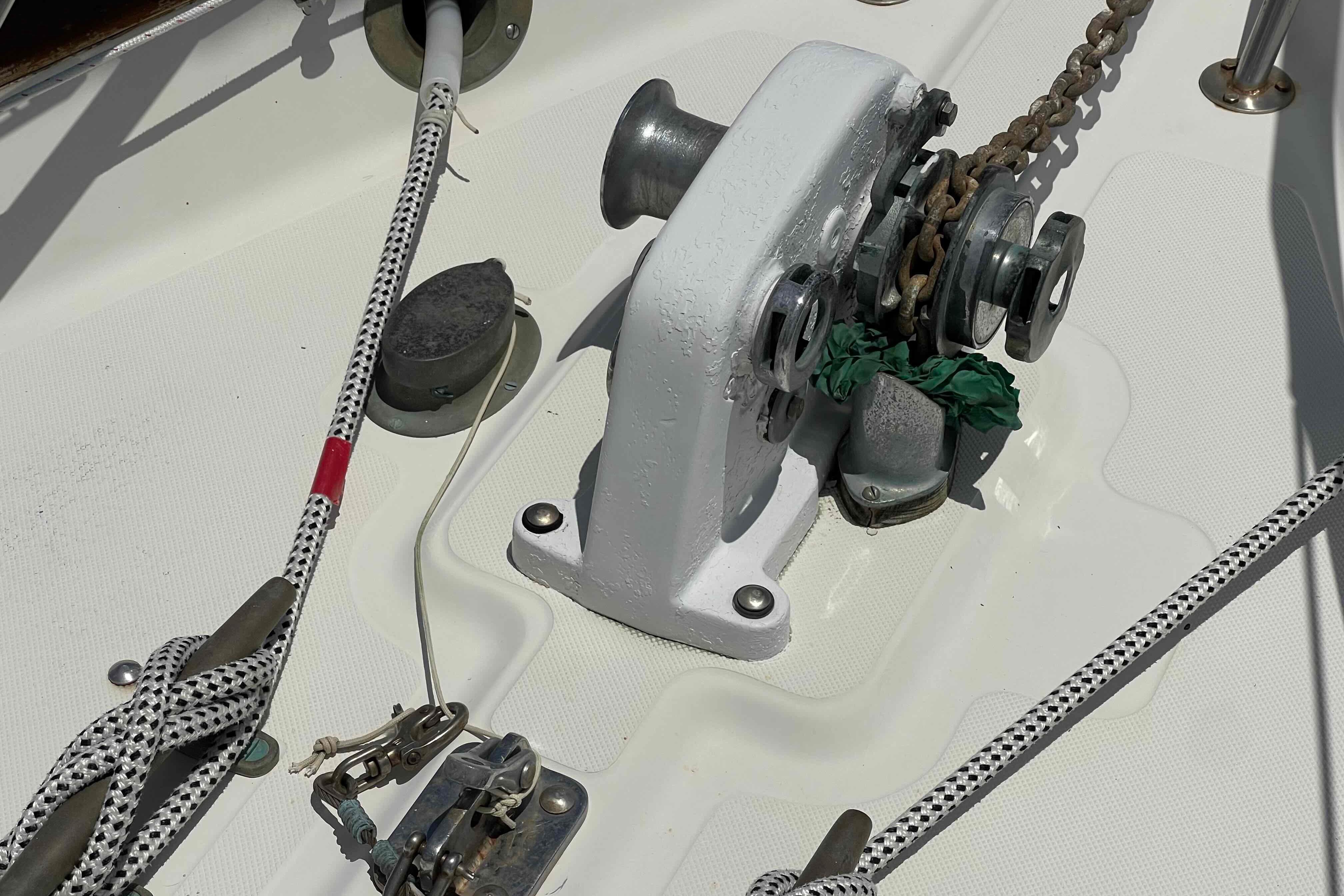 Anchor windlass on 1987 Pacific Seacraft 34 sailboat deck with ropes and chain.