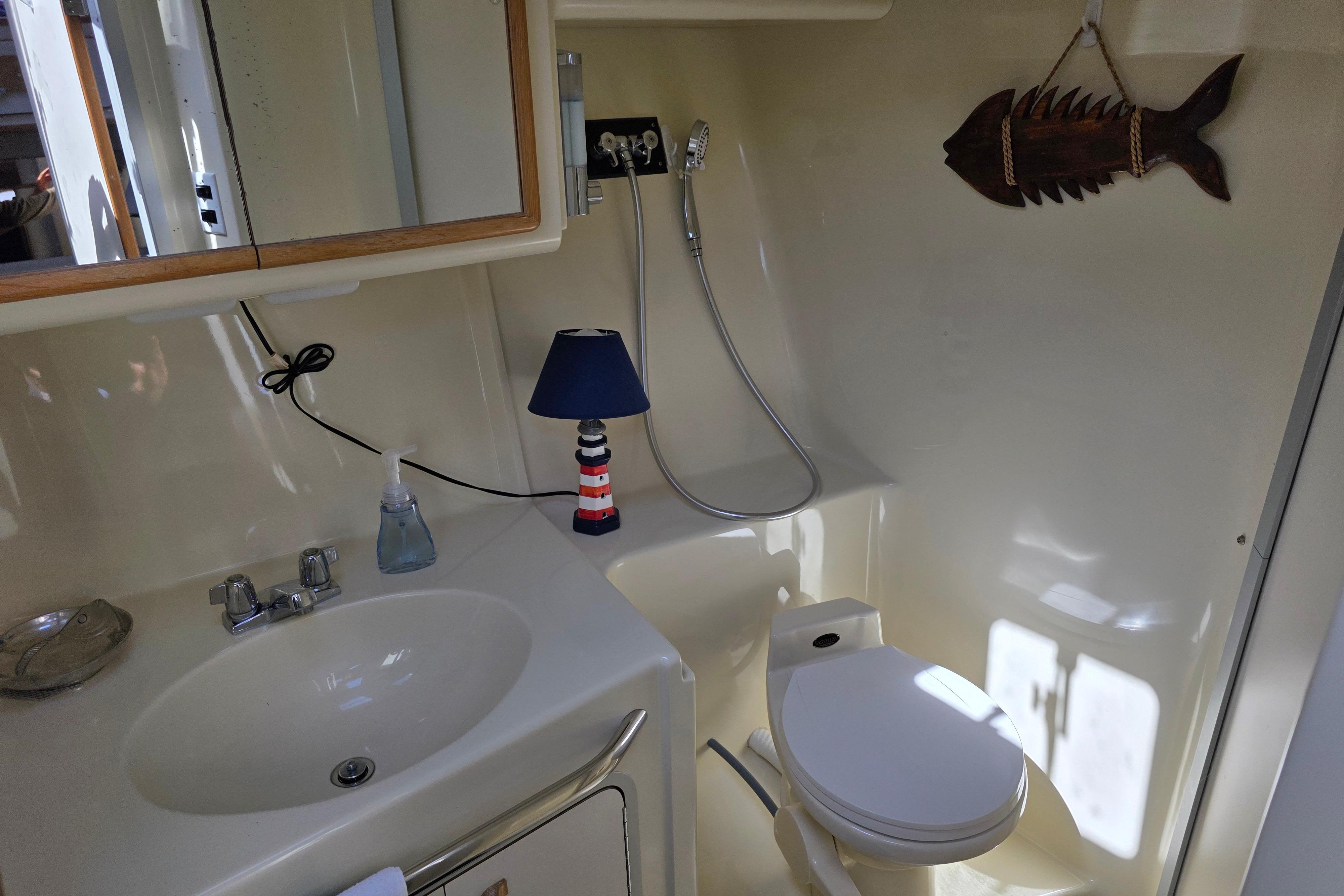 1994 Sea Ray 370 Express Cruiser bathroom with sink, toilet, mirror, and nautical decor.