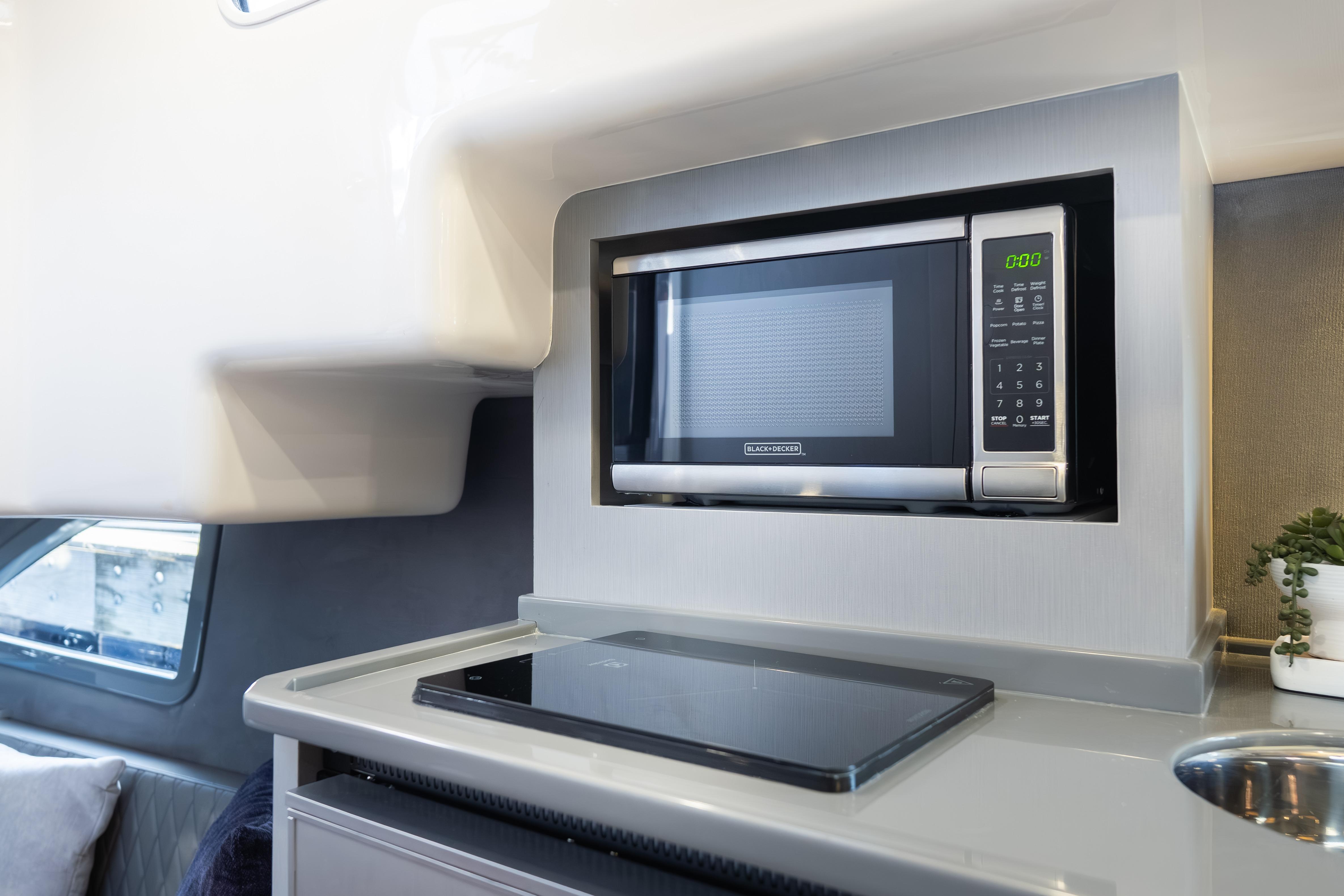 Modern kitchen area in Hanover 347 yacht, featuring a built-in microwave and sleek cooktop, 2026 model.