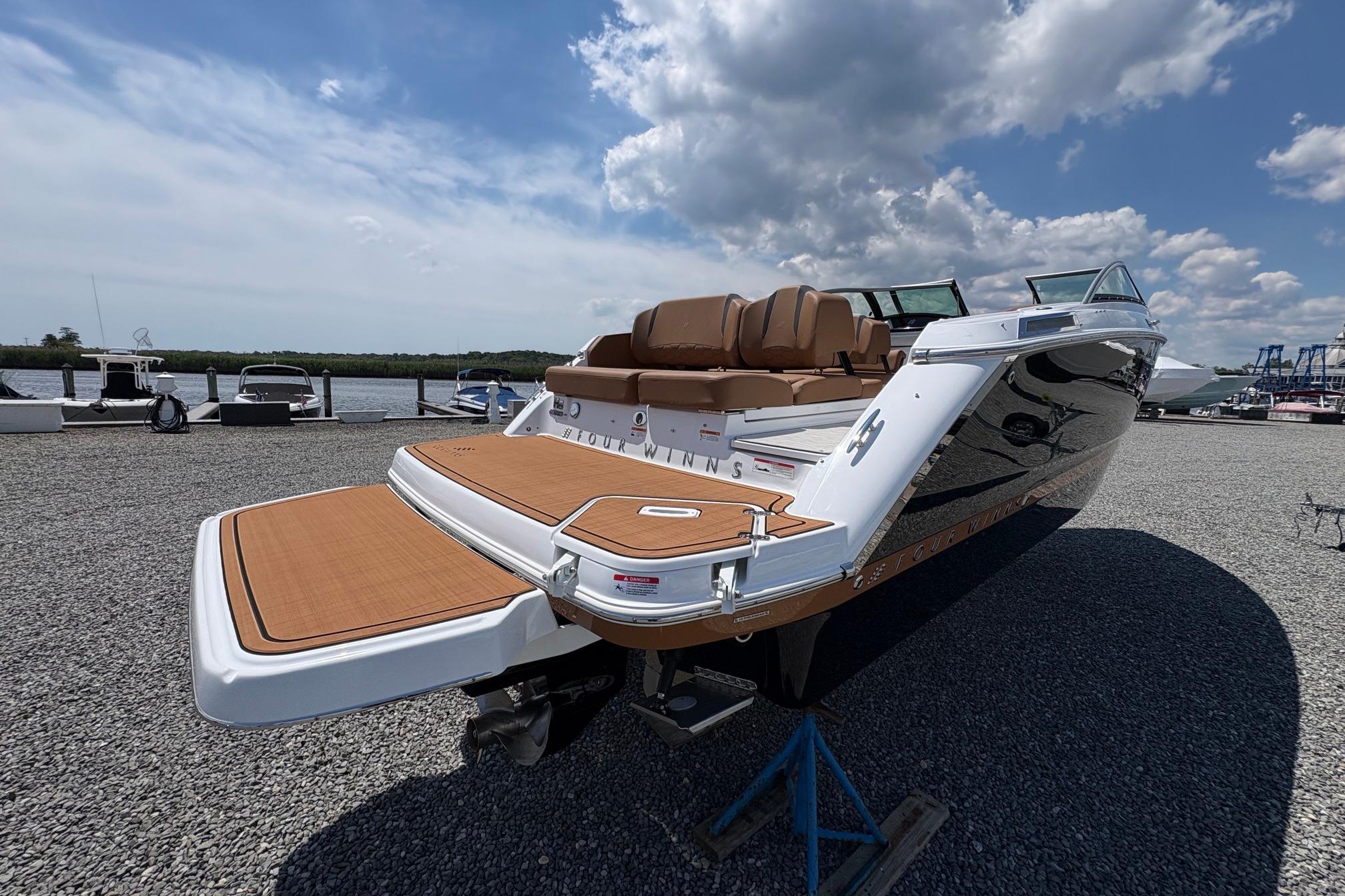 2026 Four Winns H6 boat with sleek design, docked under a partly cloudy sky.