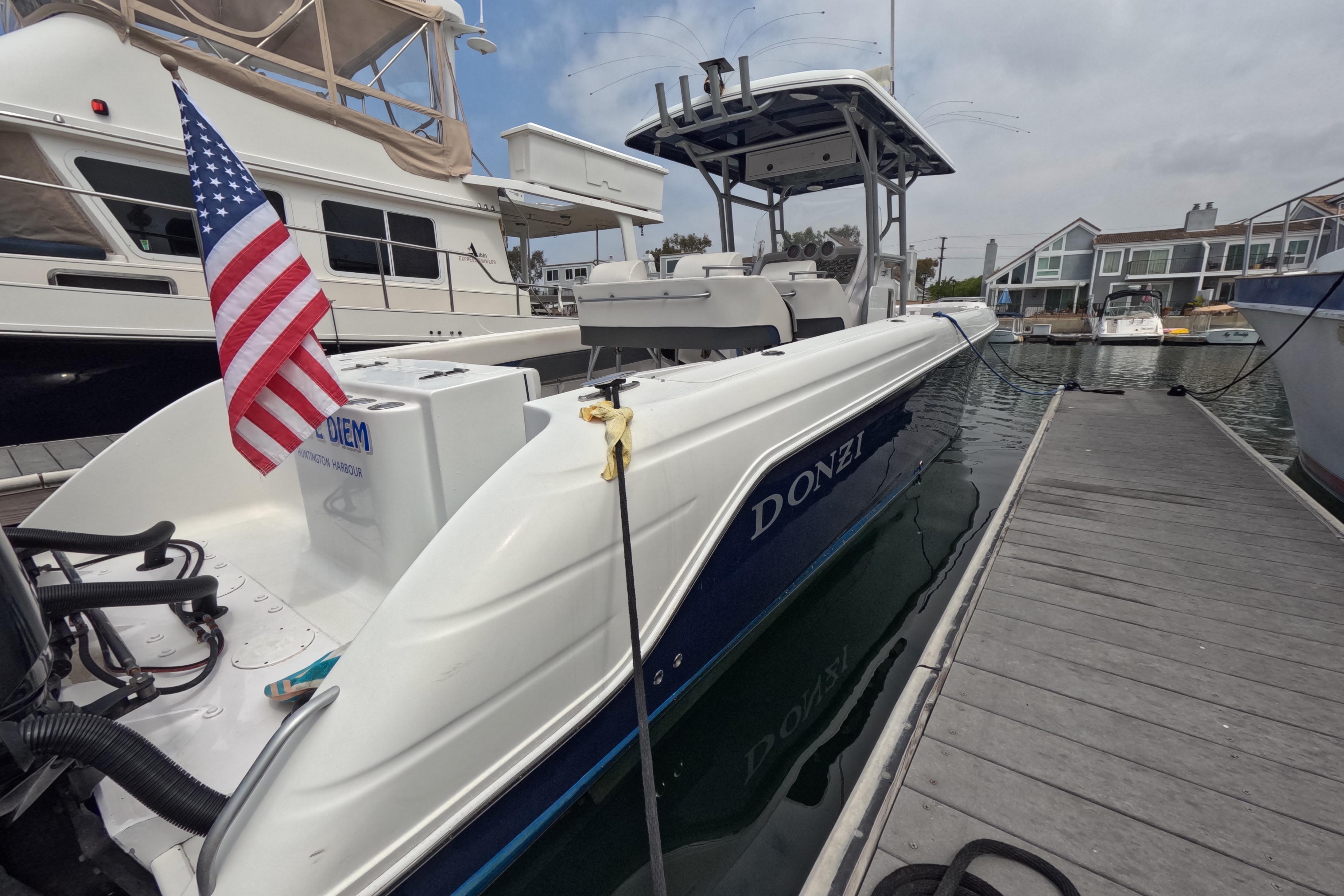 2011 Donzi 38 ZFX Open boat docked, displaying an American flag.