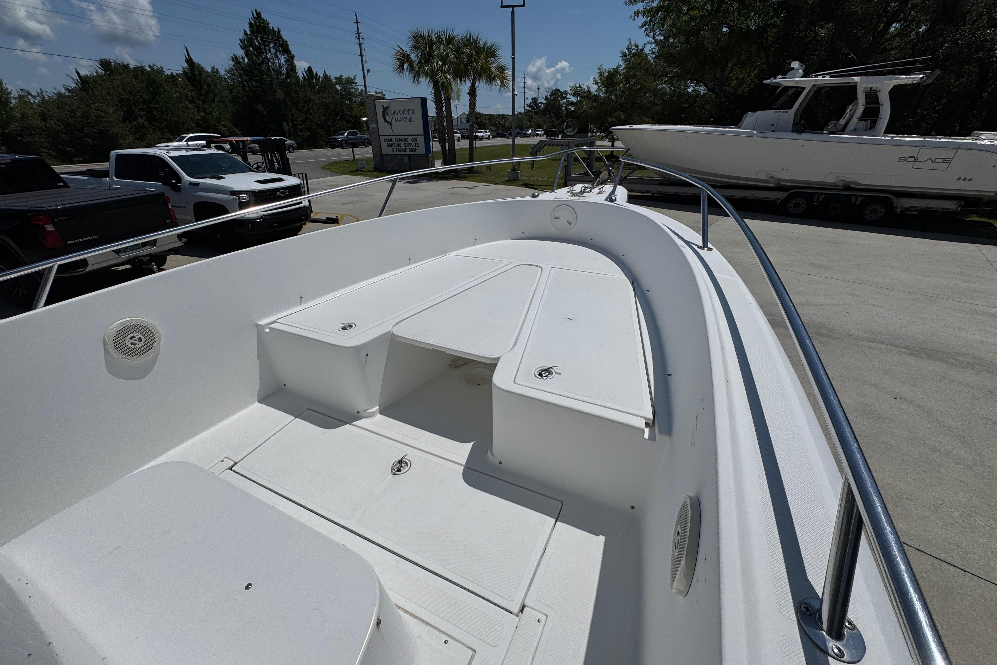 2000 Stamas 250 Tarpon boat deck with seating, parked outdoors under clear sky.