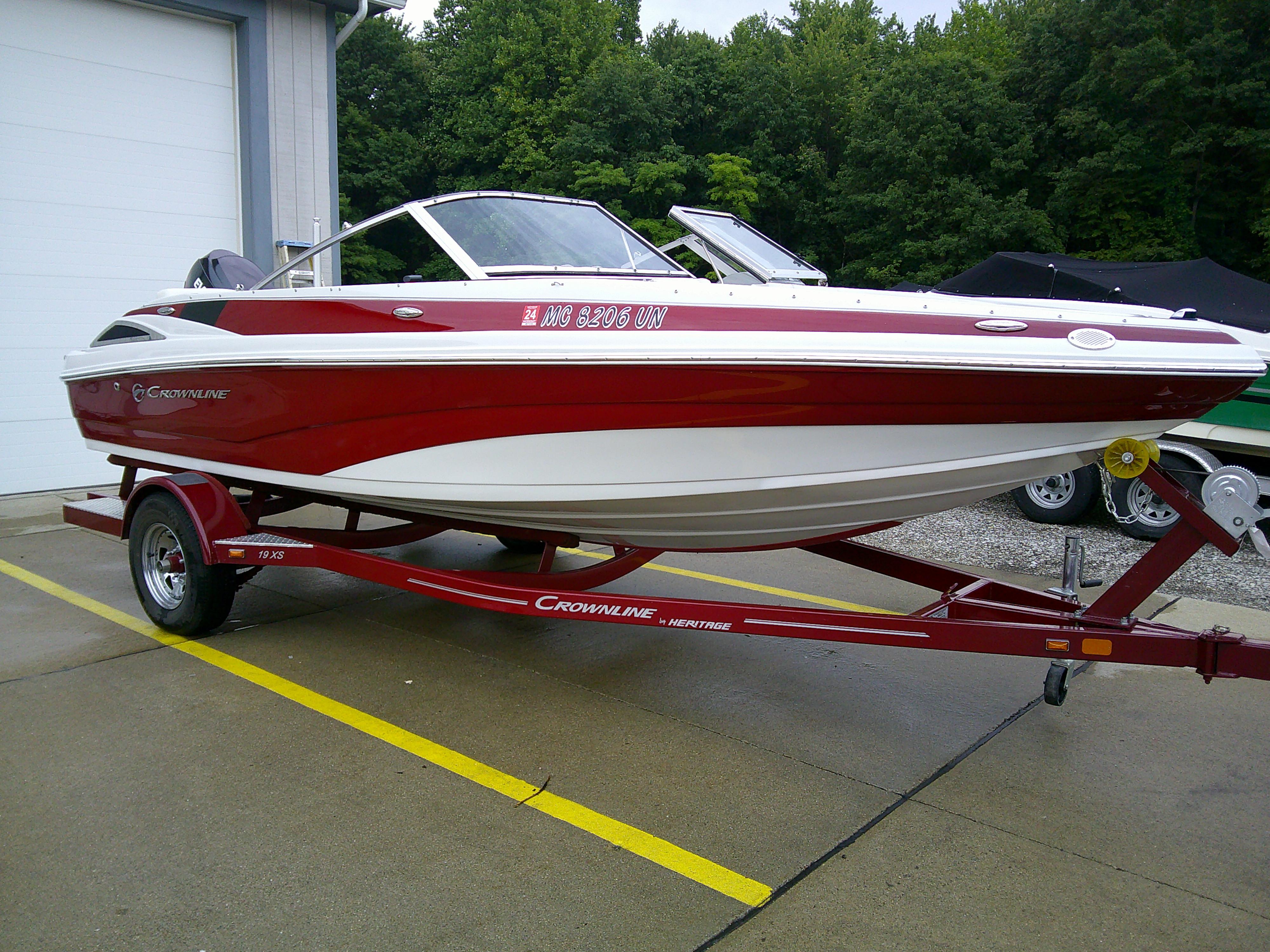2019 Crownline 19 XS boat on trailer, red and white, parked outdoors.