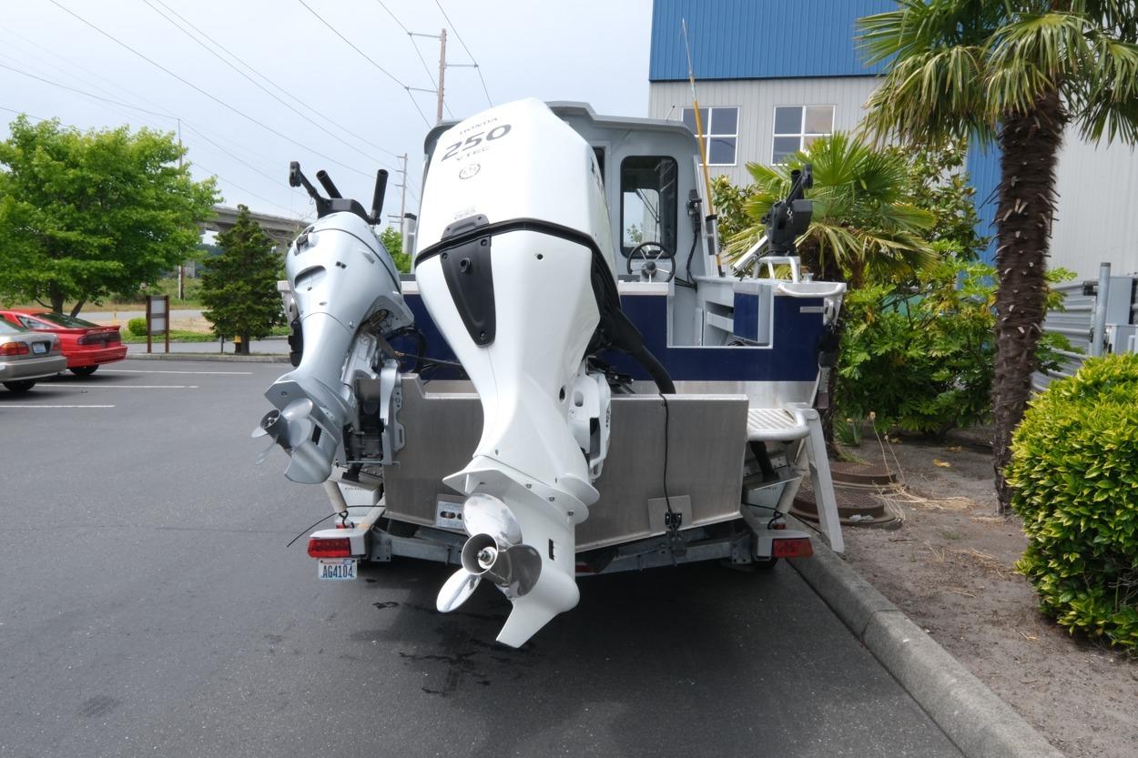 2021 Hewescraft 240 Ocean Pro ET Hardtop with dual outboard motors in a parking lot.