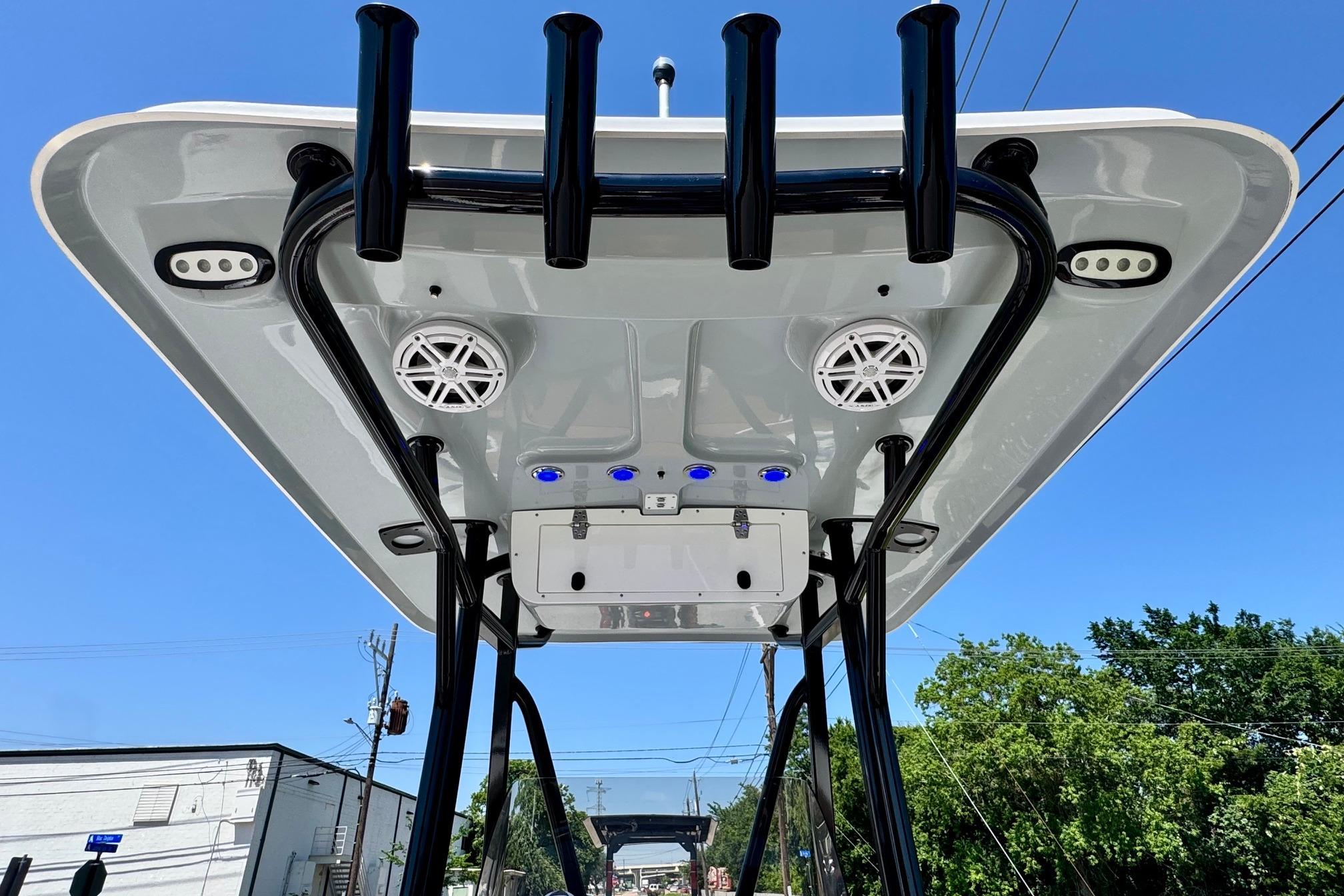 2025 Sea Hunt Ultra 219 boat top view with speakers and rod holders against blue sky.