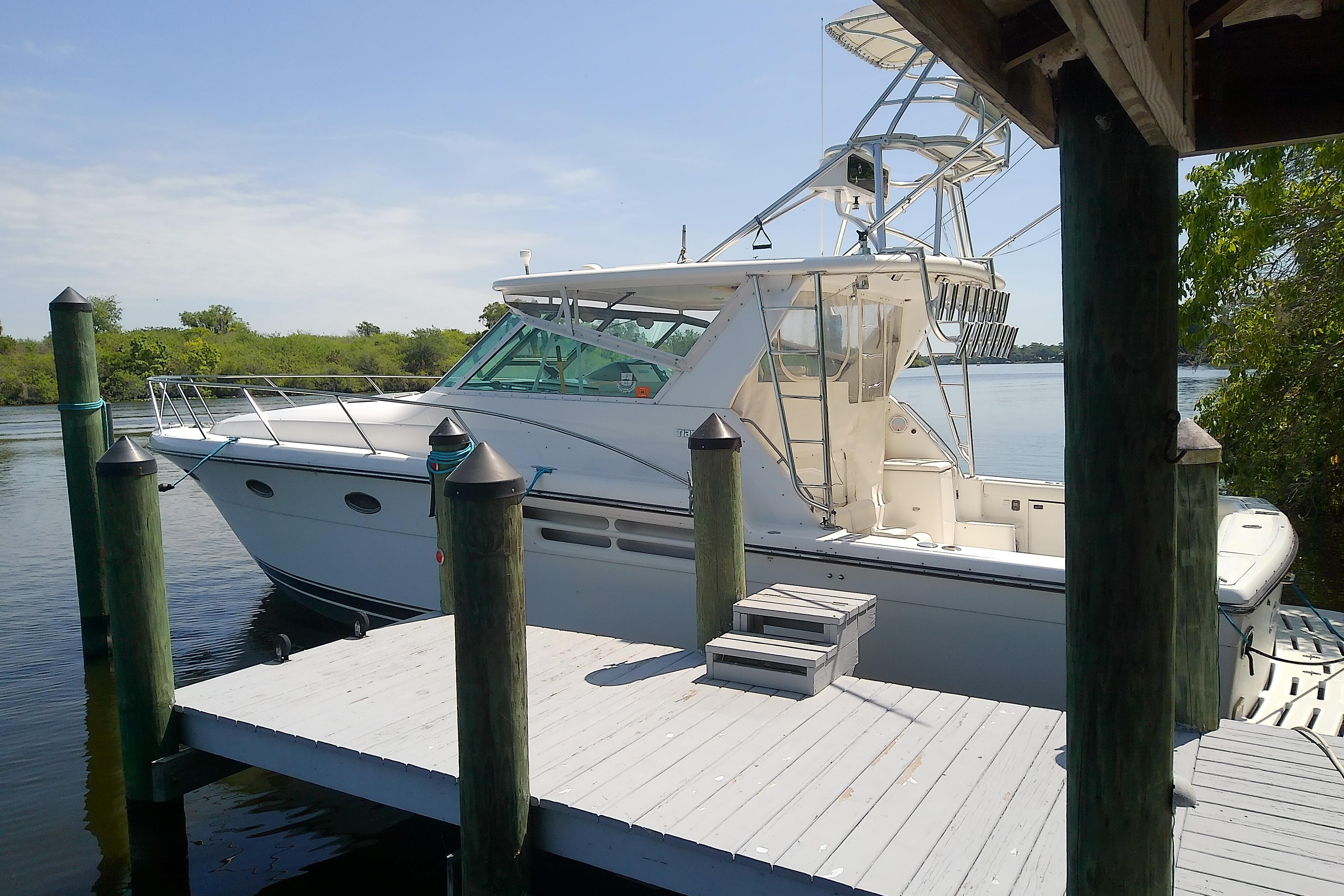 2000 Tiara Yachts 4100 Open docked by a wooden pier on a sunny day.