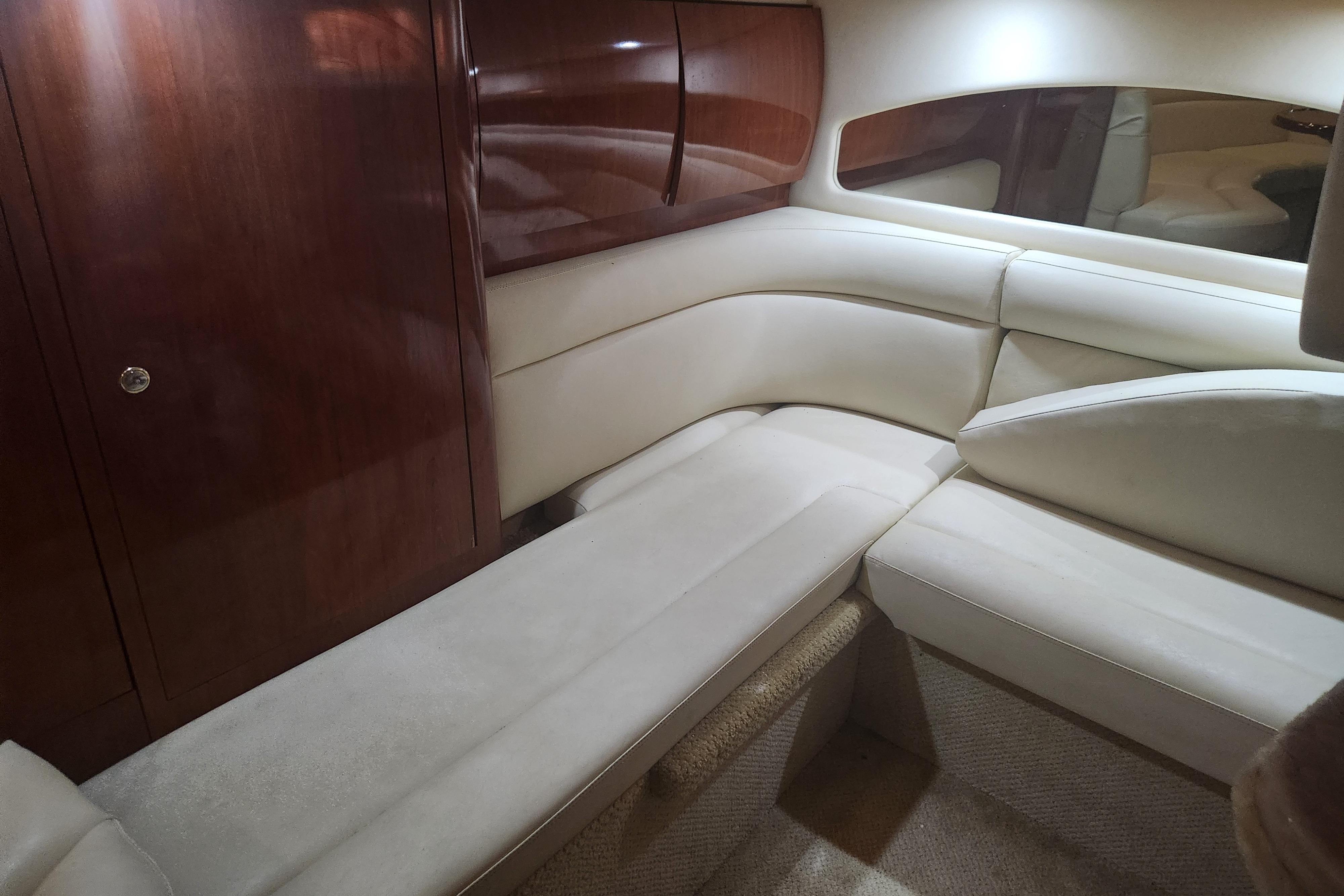 Luxurious interior of 2003 Sea Ray 360 Sundancer with plush seating and wooden cabinetry.