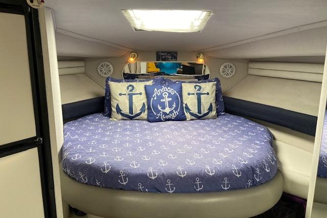 Interior of 1994 Cruisers Yachts 3675 Esprit with nautical-themed bedding and anchor pillows.