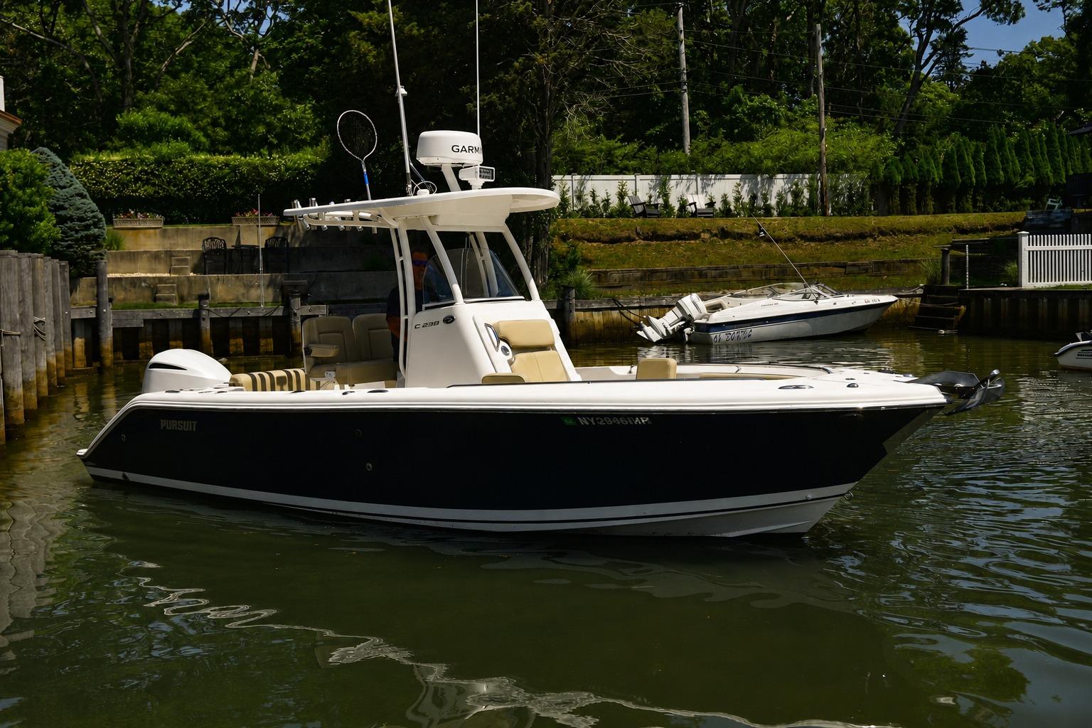 2020 Pursuit C 238 Center Console boat docked in a serene marina setting.