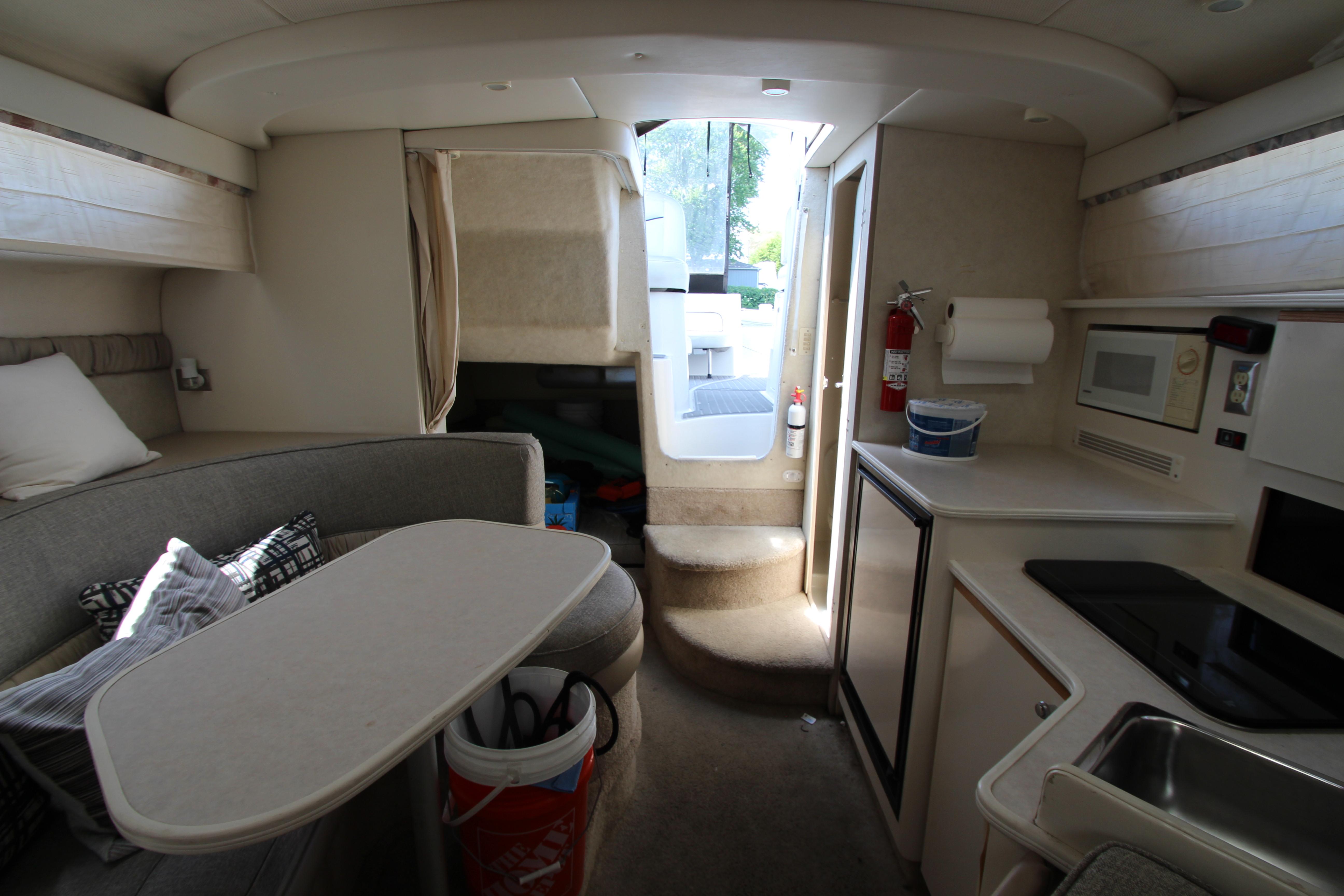 Interior of 1999 Bayliner 3055 Ciera boat with kitchenette and seating area.