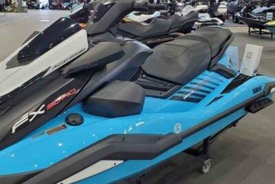 A blue Yamaha WaveRunner FX SVHO jet ski is displayed in a showroom.