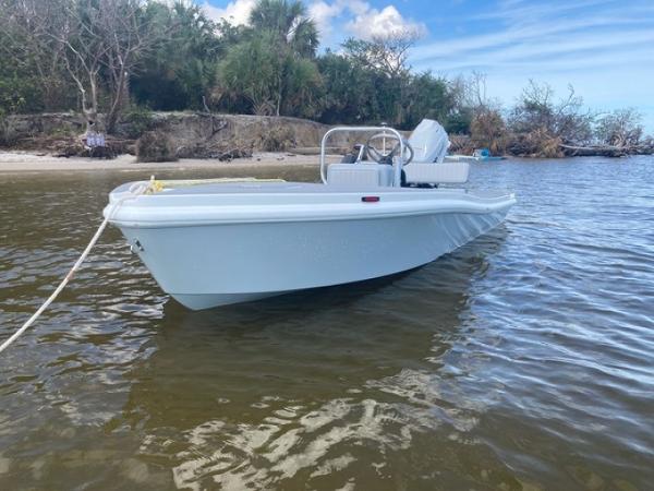 2024 Ultra Lite Tenders ULT 380 boat anchored near a scenic shoreline.