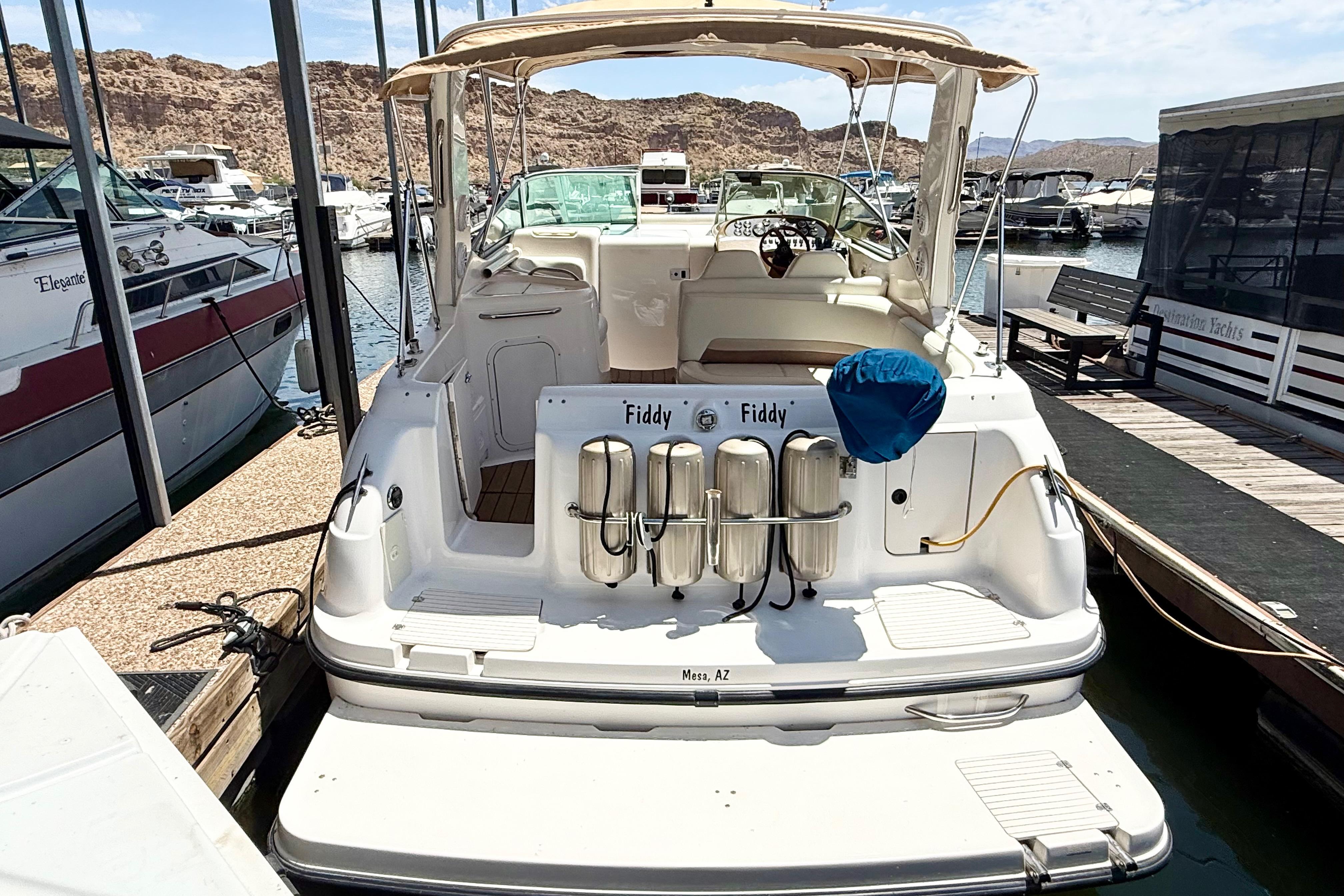 1999 Chaparral Signature 300 boat docked at marina, rear view with seating and equipment.