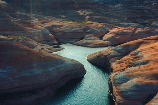 Aerial view of winding river through rocky canyon landscape, captured by Adonia's The Queen Elizabeth, 2021.