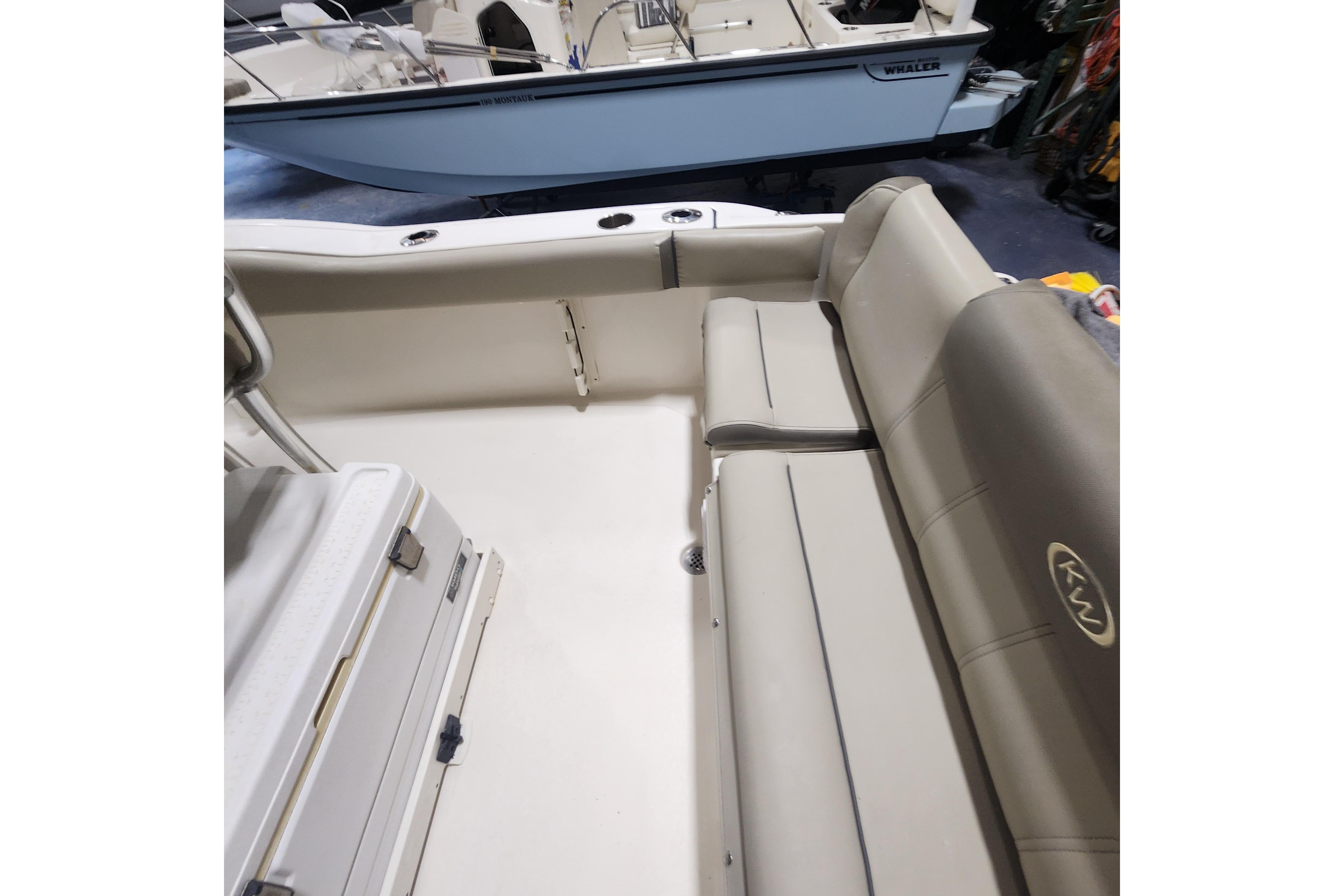 2023 Key West 219 FS boat interior with cushioned seating and storage area.