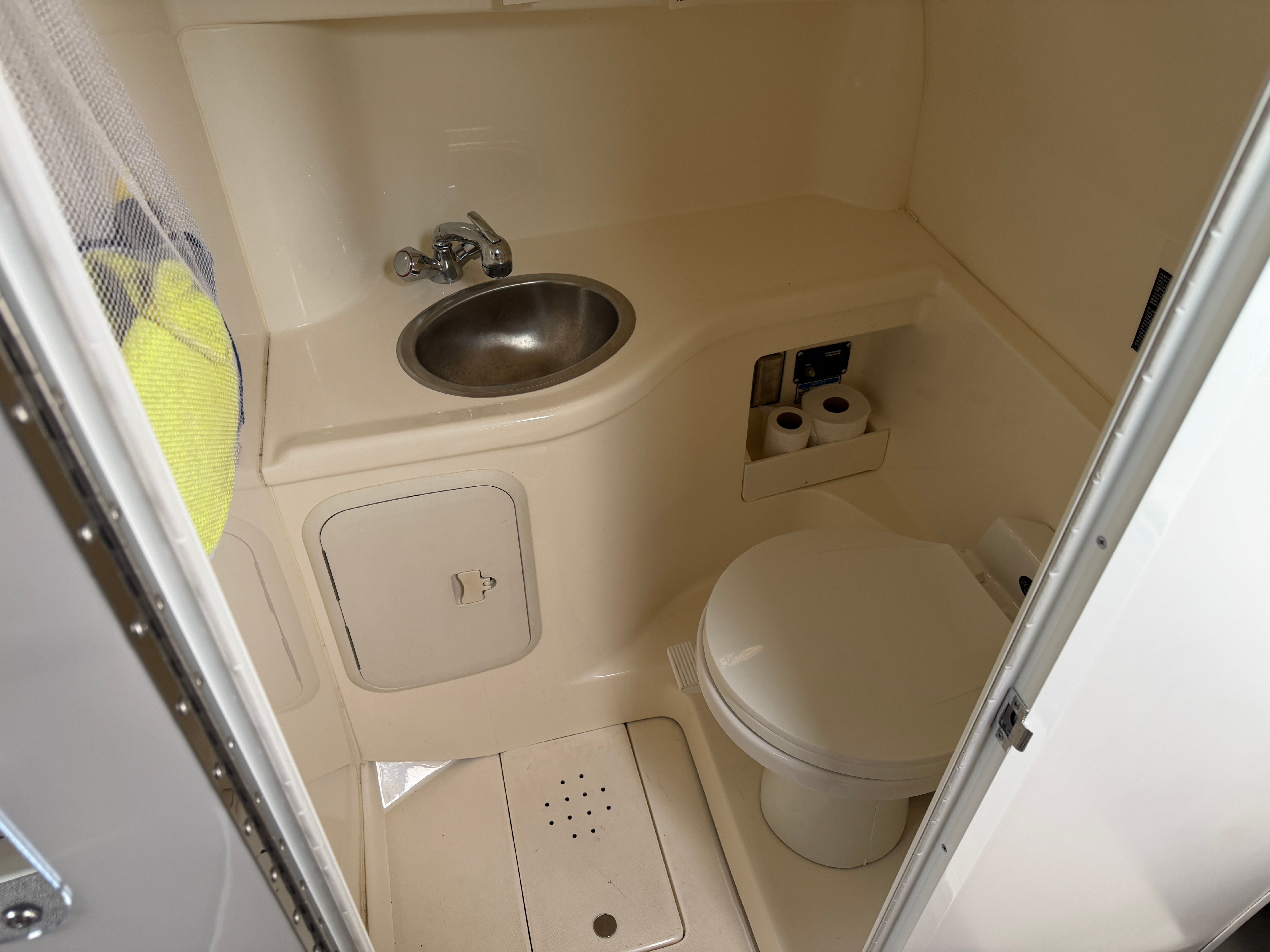 The image shows a boat bathroom with a sink and toilet.