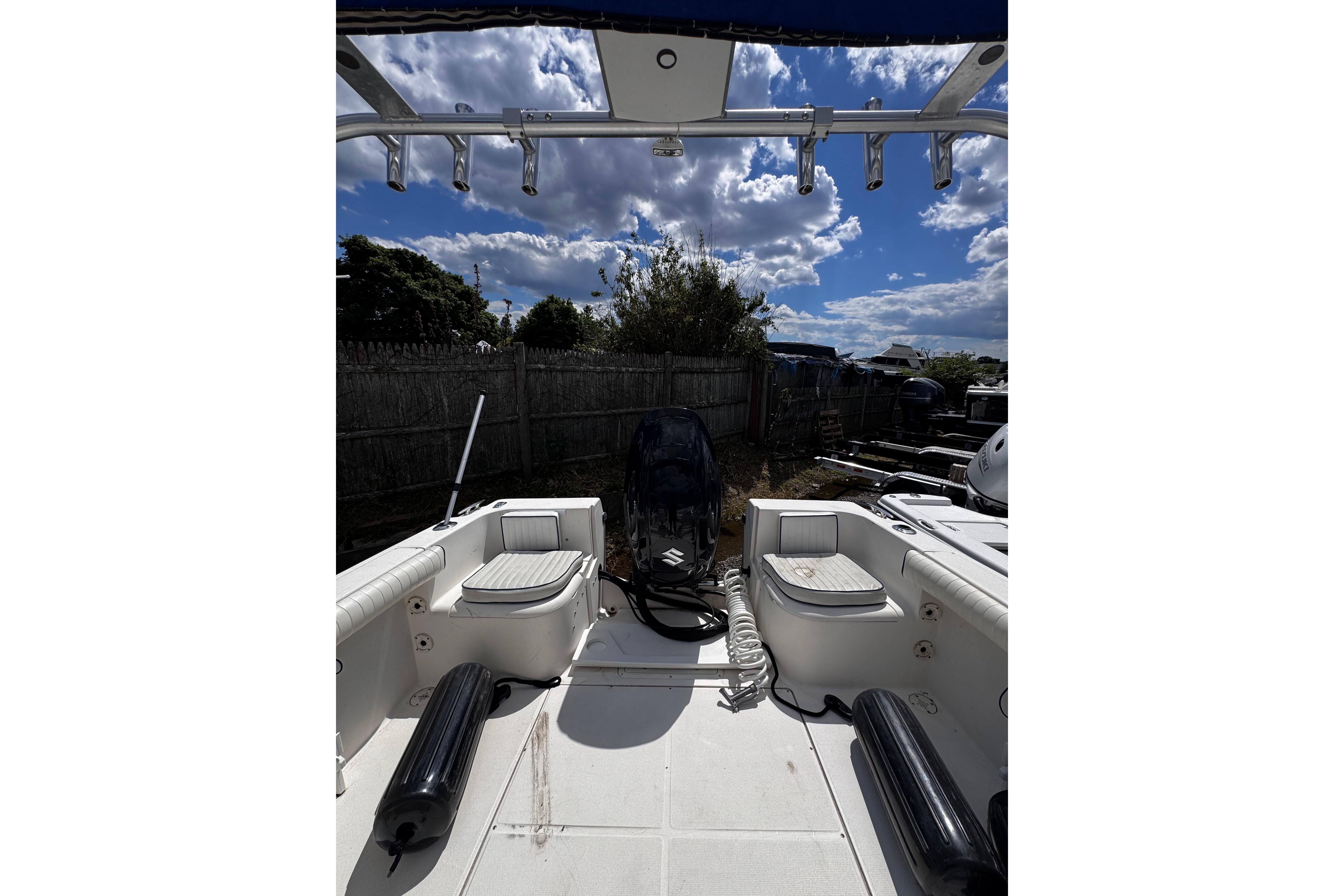 2003 Palm Beach 2200 Dual Console boat with seating and motor, under a partly cloudy sky.